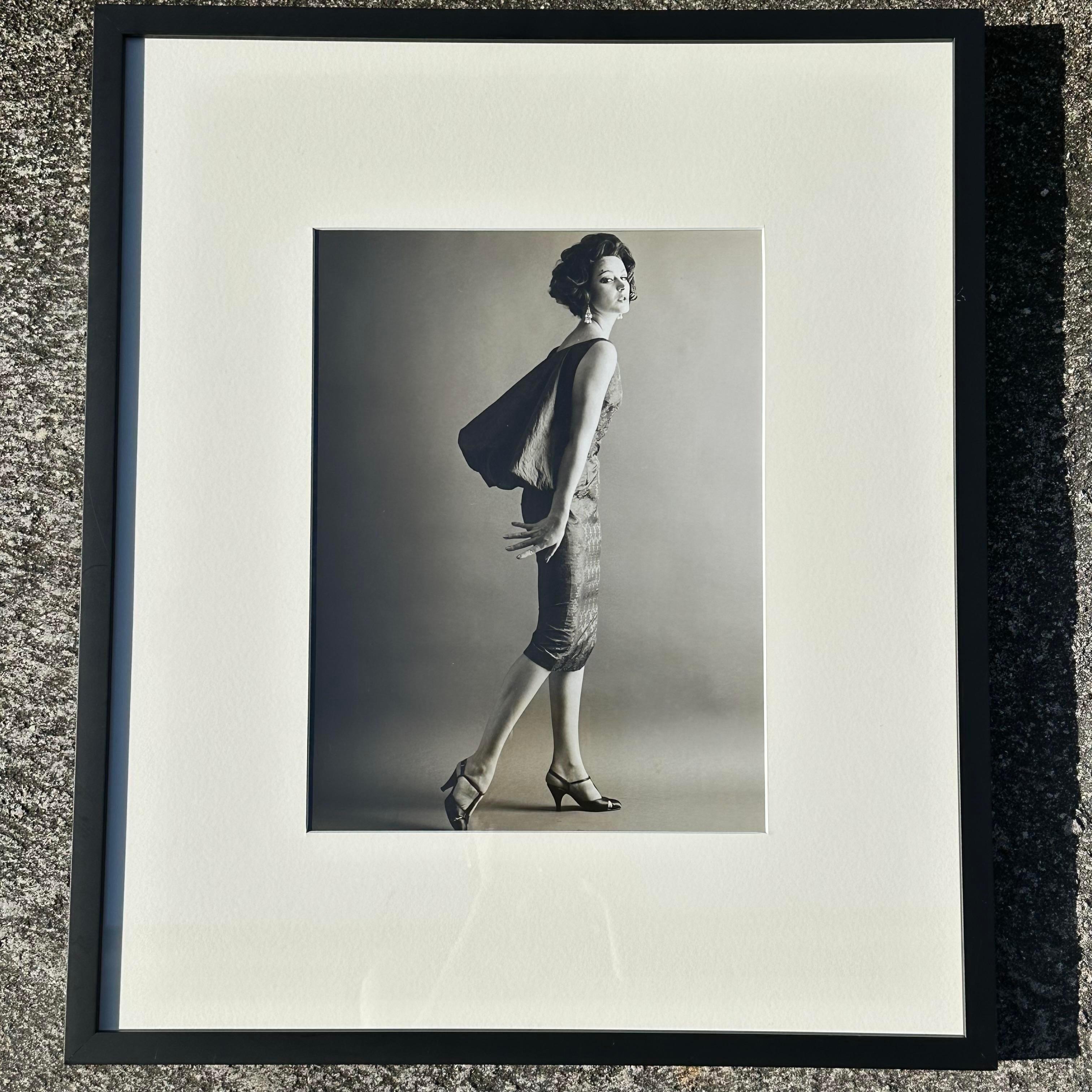 A gorgeous vintage 1950 photograph of a woman in a fashion photoshoot. The picture is framed a very fitting black frame that makes the picture classy. It looks great alone or in a set. Acquired at a Palm Beach estate.
