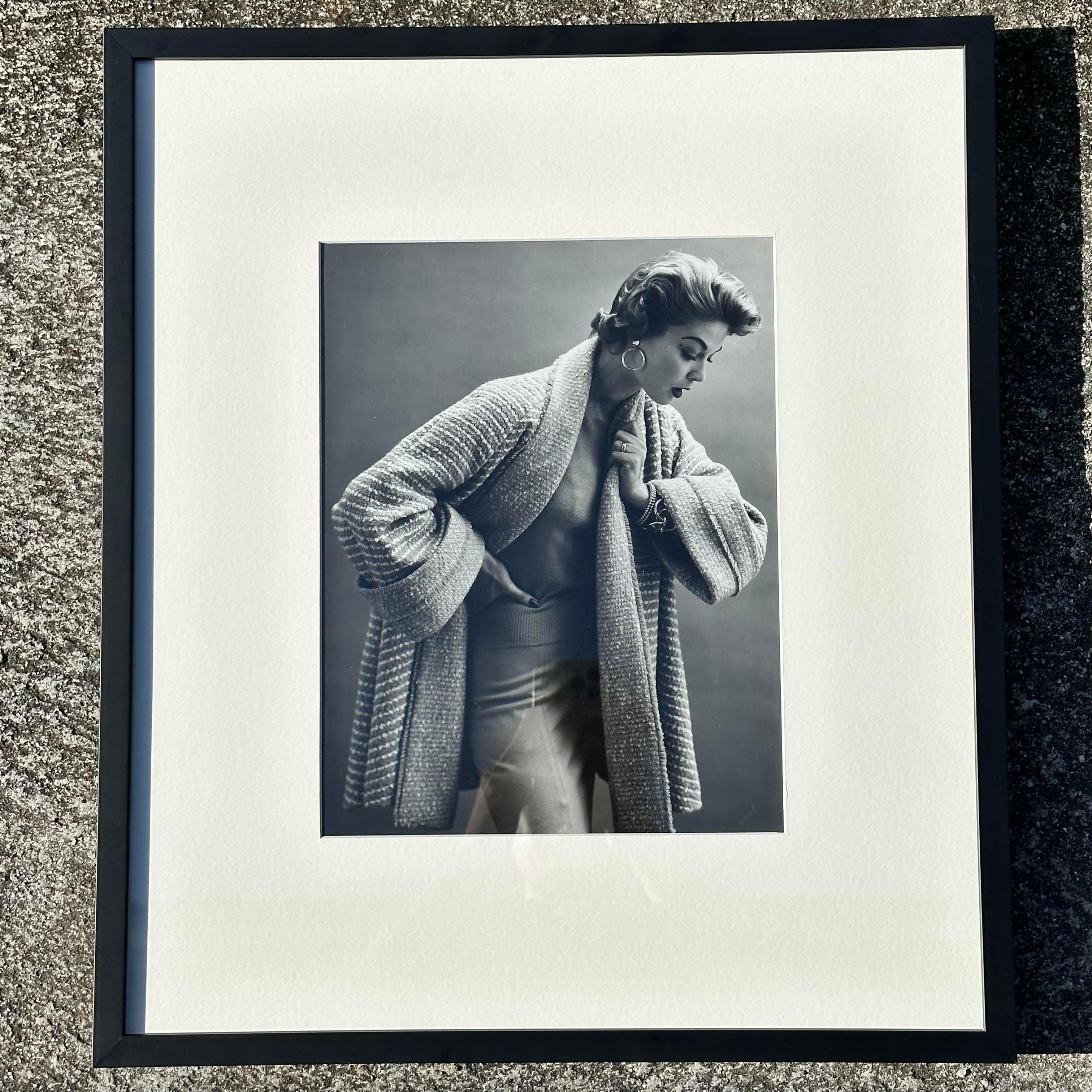 A gorgeous vintage 1950 photograph of a woman in a fashion photoshoot. The picture is framed a very fitting black frame that makes the picture classy. It looks great alone or in a set. Acquired at a Palm Beach estate.