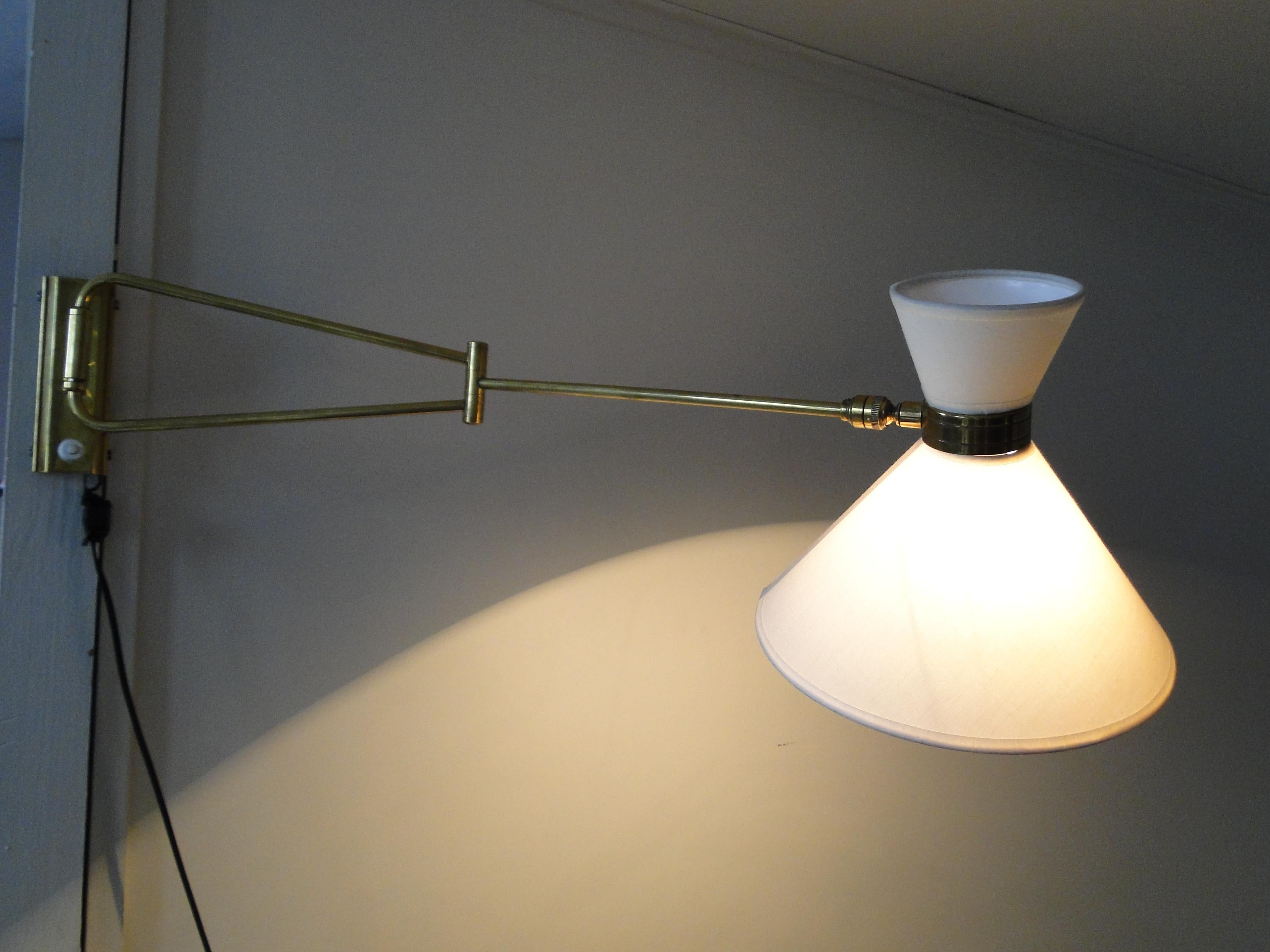 Wall light by René Mathieu from the 1950s.

2-arm articulated brass stem.

New lampshade 3.93 and 8.66 in diameter.
 
