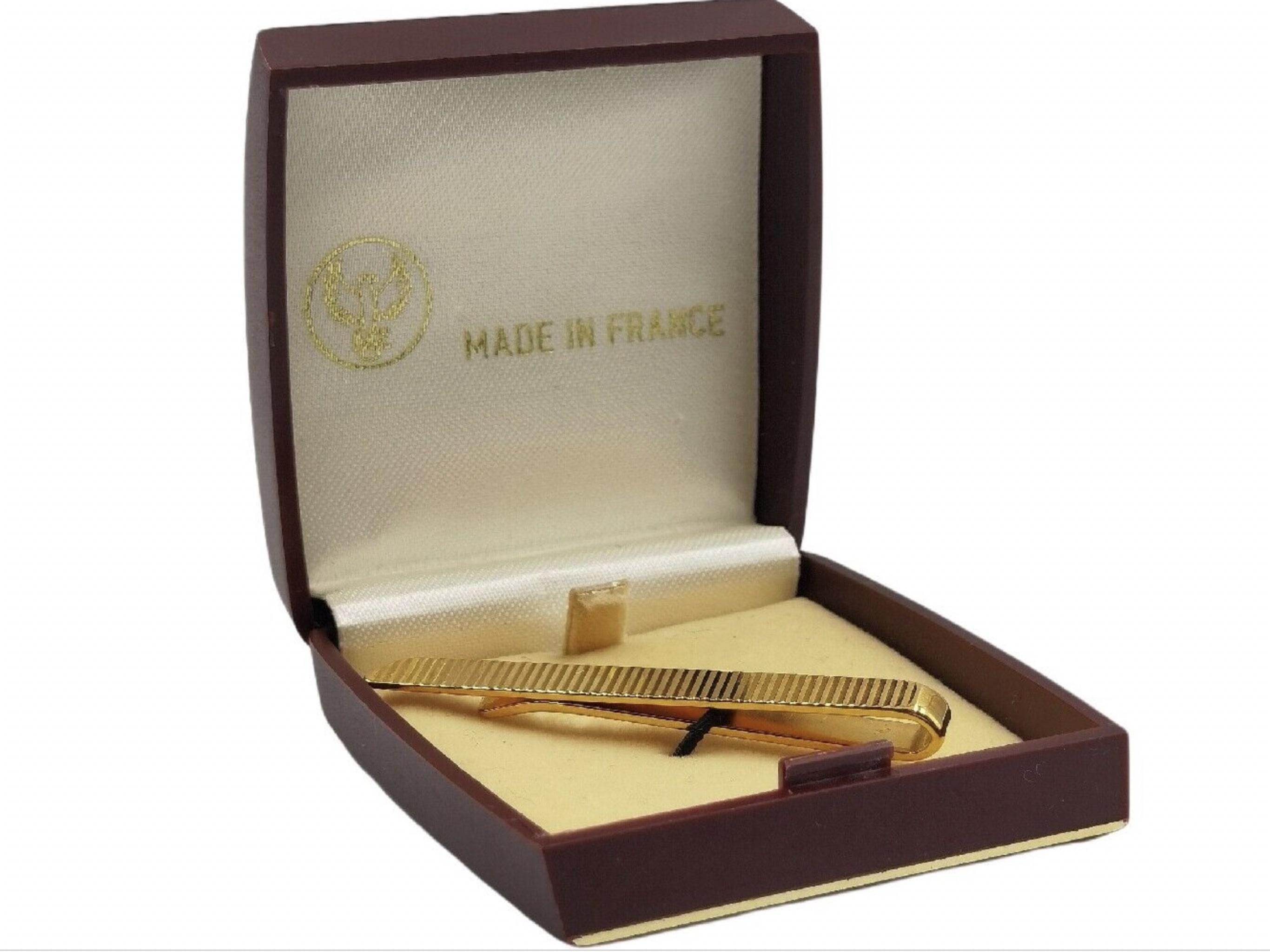 Vintage tie clip 
Gold plates 
Made in France 
Dates back to the 1950s
It is still in its original box 
Looks like the tie clip and the box have not been used 
Art Deco 
Perfect for a gift 