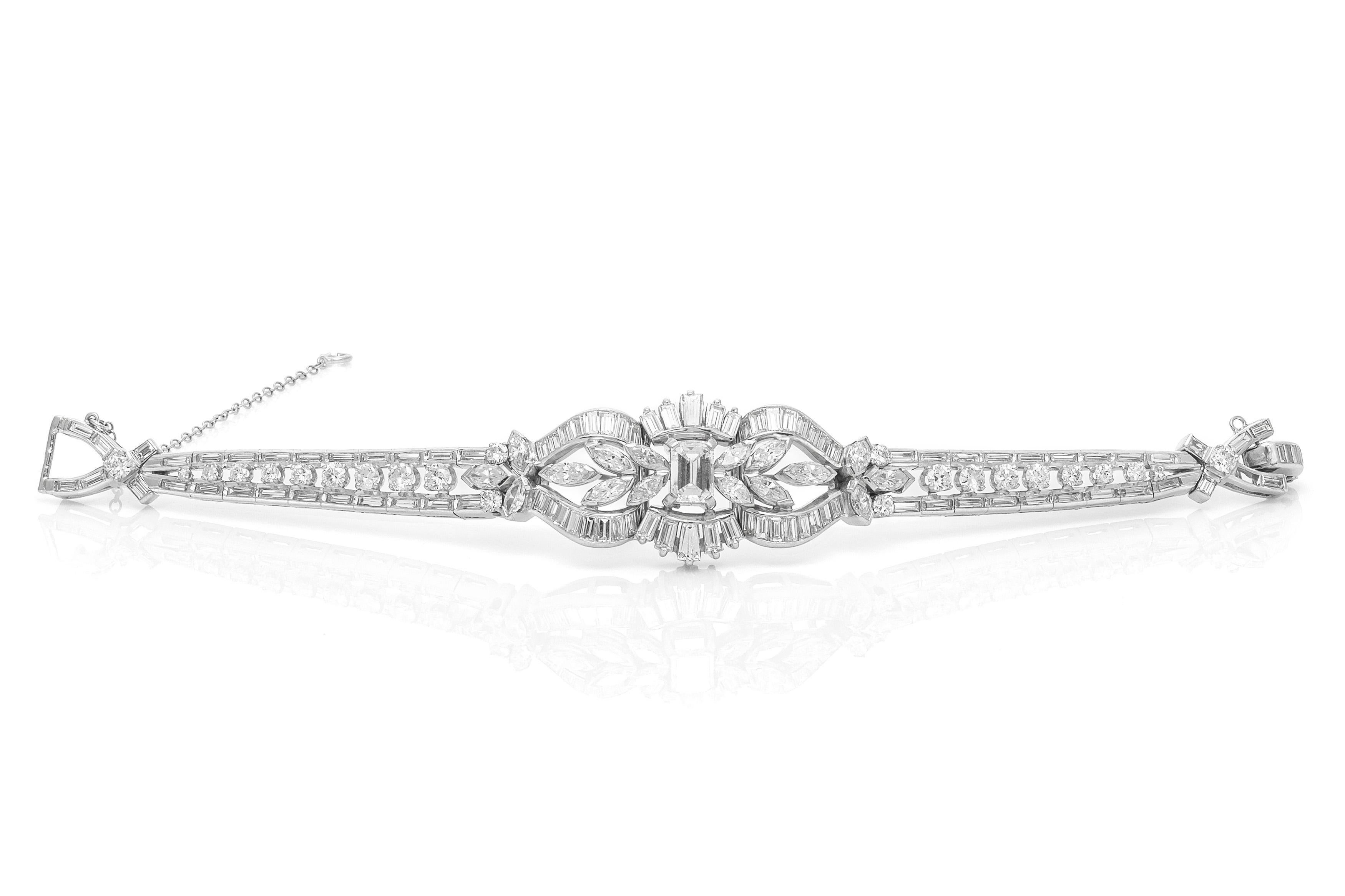Finement réalisé en platine avec un diamant de taille émeraude au centre pesant environ 1,50 carat, et des diamants de taille ronde, brillante, baguette et marquise pesant au total environ 12,00 carats. 
Circa 1950s
Taille 6 1/4 pouces