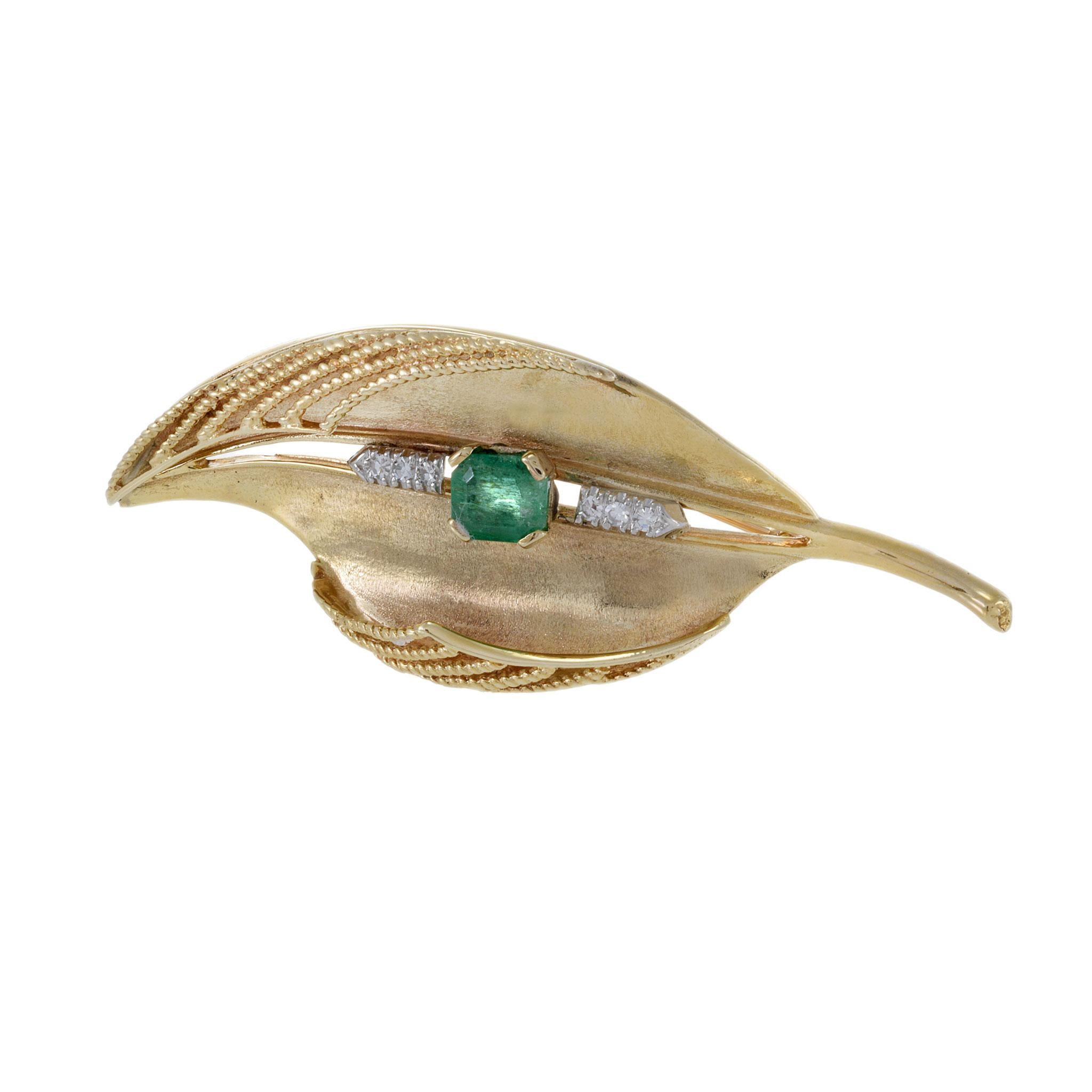 Vintage 1950s 14KT Yellow Gold Emerald And Diamond Leaf Brooch, featuring a stunning 1.50 carat emerald cut emerald and sparkling diamonds totaling 0.18 carats. Weighing 17.81 grams, this elegant piece captures the essence of mid-century