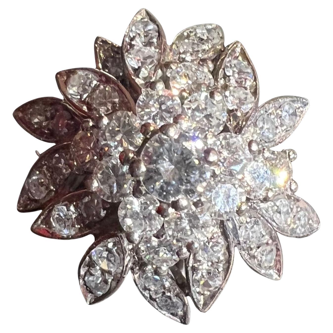Este anillo escultural de los años 50 encanta por su alegre silueta y su elegancia vintage. Realizado en oro blanco de 18 quilates, adopta la forma de una flor floreciente, y sus voluminosos pétalos arremolinados evocan juguetonamente un delicado