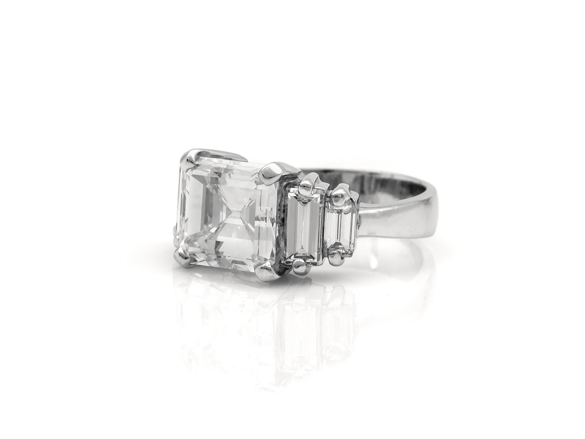 Fein in Handarbeit in Platin mit einem Ost-West-Set GIA zertifiziert Emerald Cut Diamond mit einem Gewicht von 3,75 Karat, I Farbe, VS1 Klarheit, GIA # 6187376388.
Der Ring hat 4 Diamanten im Baguetteschliff mit einem Gesamtgewicht von etwa 1,10