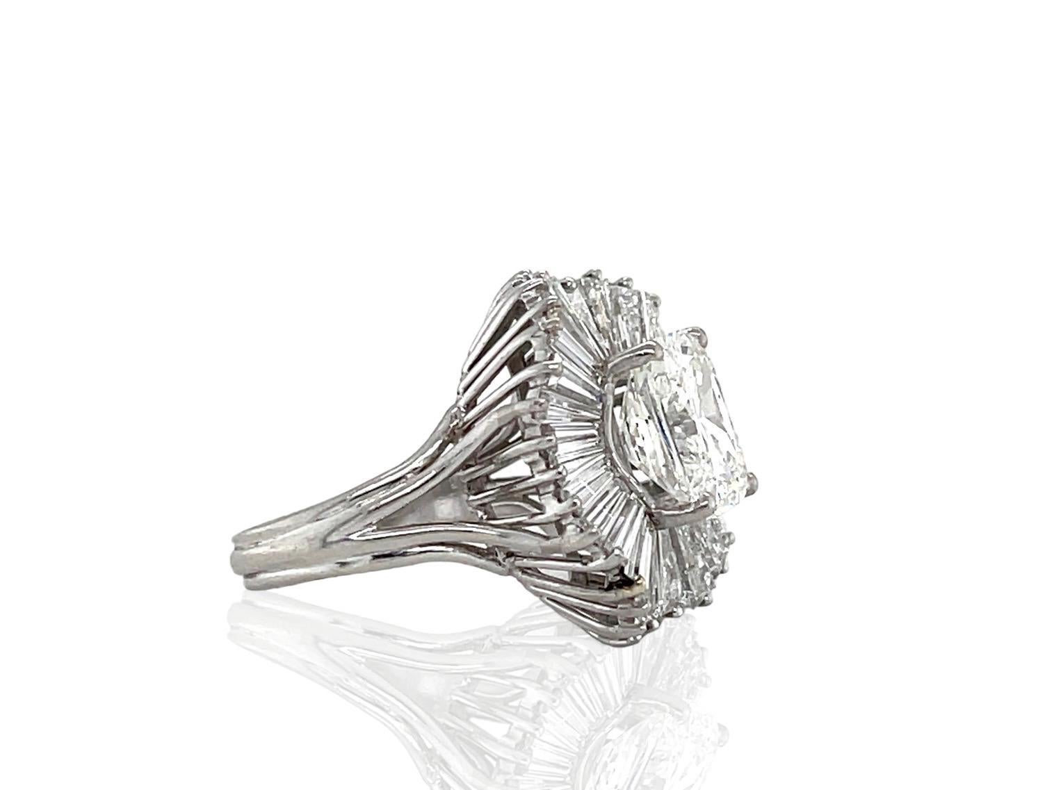 Finely crafted in platinum with a GIA certified Radiant cut center Diamond weighing 5.13 carats, I color, SI1 clarity, GIA#2105435628.
The center diamond is set in a ballerina setting with Tapered Baguette cut Diamonds weighing approximately a total