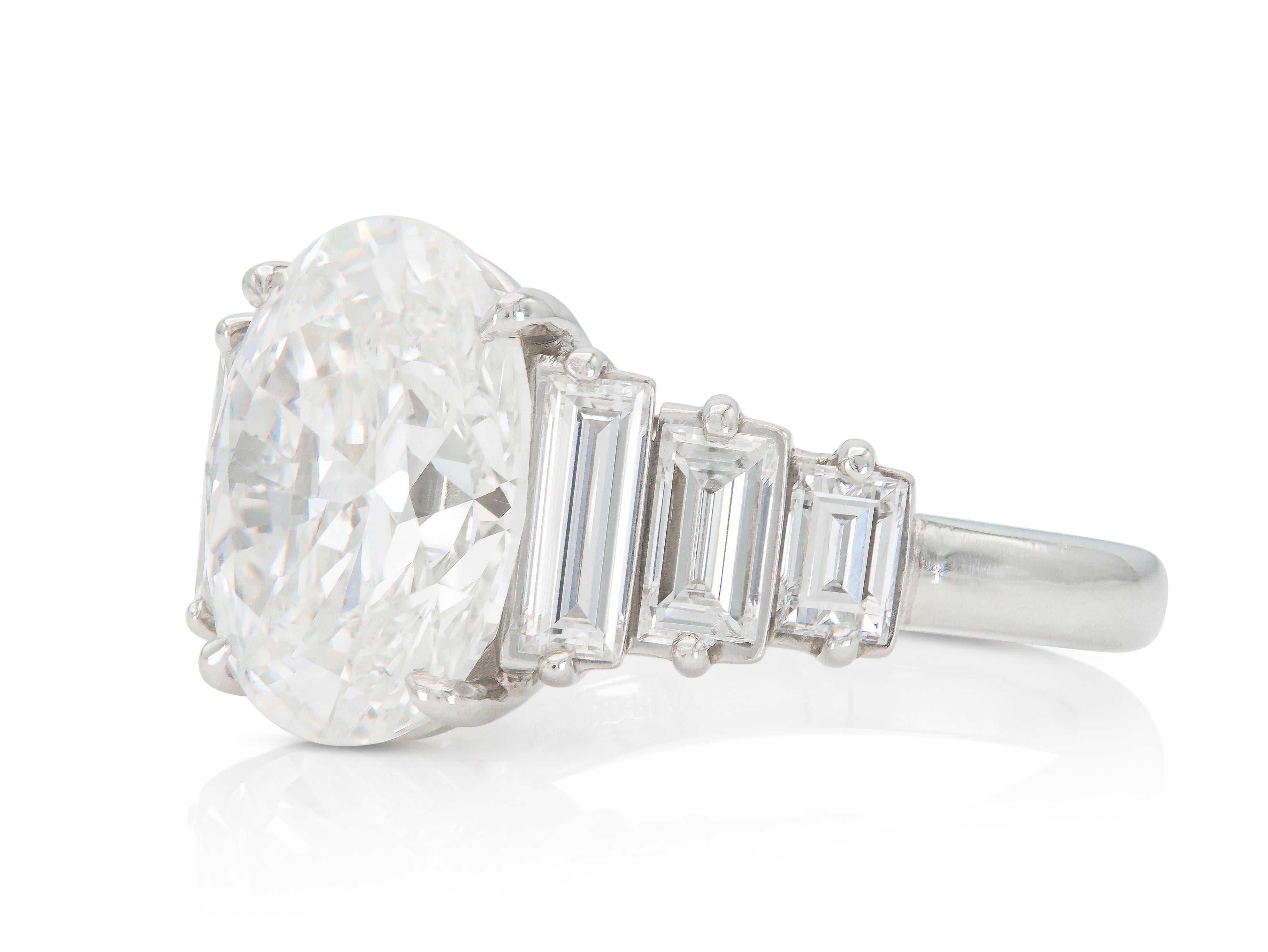 Finement réalisé en platine avec un diamant de taille ovale certifié par le GIA pesant 5,23 carats, couleur G, pureté SI1, numéro GIA : 12543004.
La bague comporte 6 diamants latéraux de taille baguette pesant au total 2,08 carats.
Circa