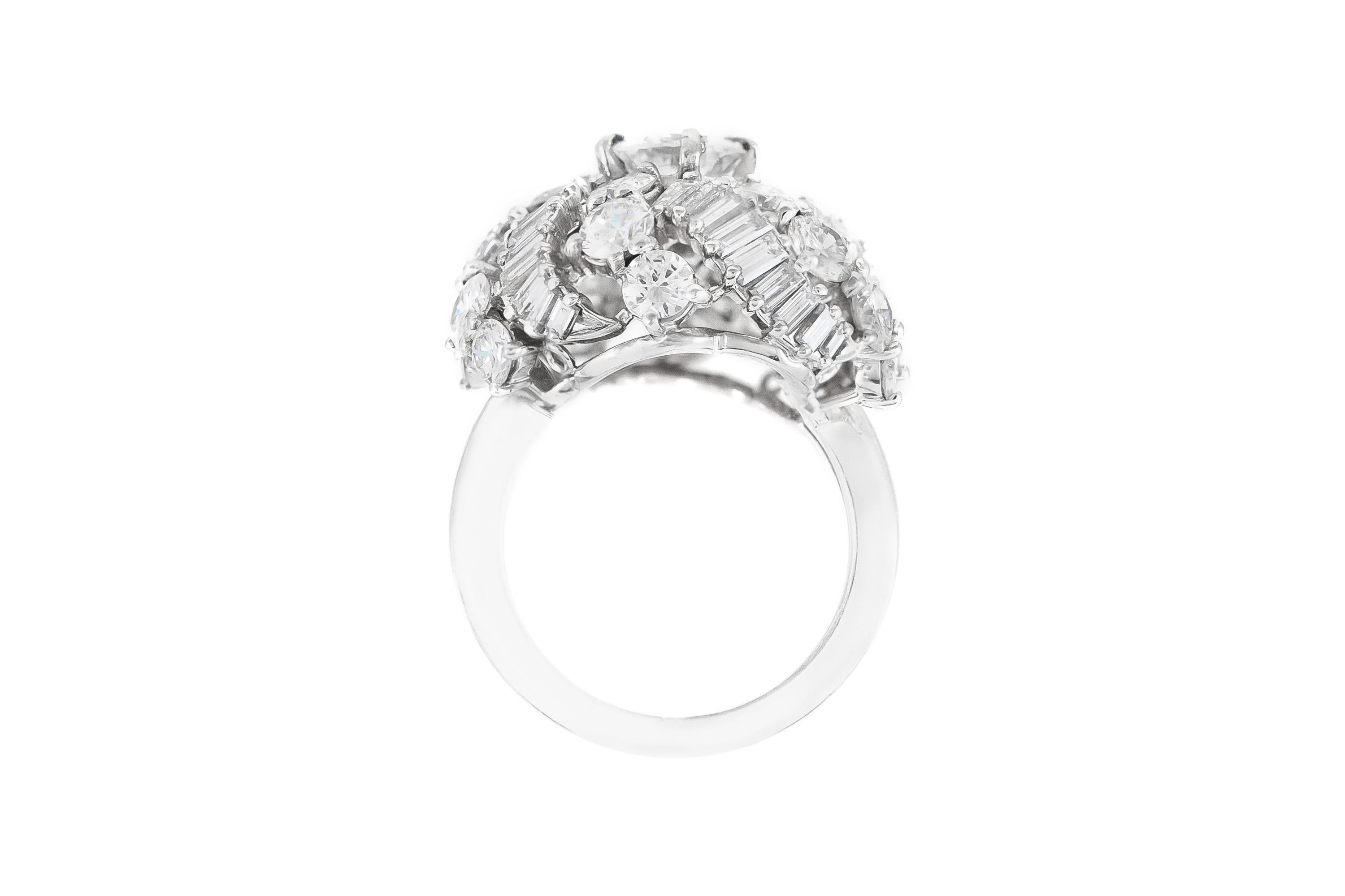 Finement réalisé en platine avec un diamant central de taille ronde et brillante pesant environ 1,00 carat, ainsi que des diamants plus petits de taille ronde et brillante et de taille baguette pesant environ 5,00 carats au total.
Circa 1950s
Taille