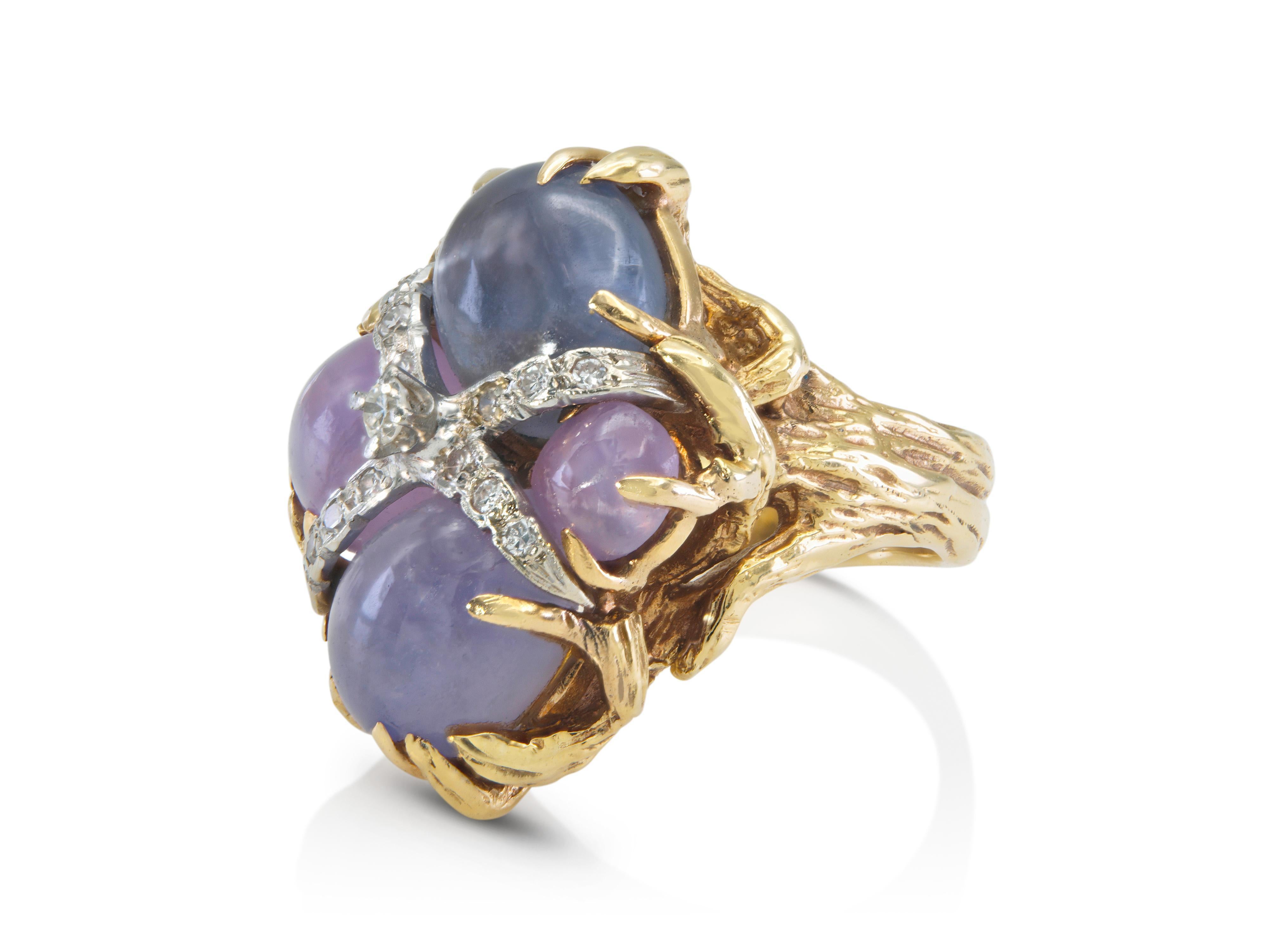 Fein in Handarbeit in 14k Gelb- und Weißgold mit 4 Cabochon Purple Star Sapphires mit einem Gesamtgewicht von ca. 8,00 Karat, sowie Round Brilliant und Single cut Diamanten mit einem Gewicht von ca. 0,20 Karat.
Circa 1950er Jahre
Größe 5 1/4,