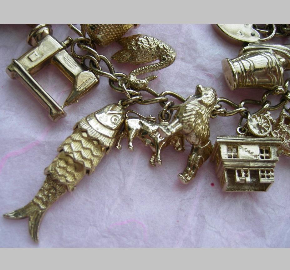 This is a more than wonderful 9k charm bracelet loaded with 24 charms, 22 are attached and 2 are loose charms, not counting the heart padlock. Charms are wonderfully worked, some of them are rarest, this is the first time that I see some unusual
