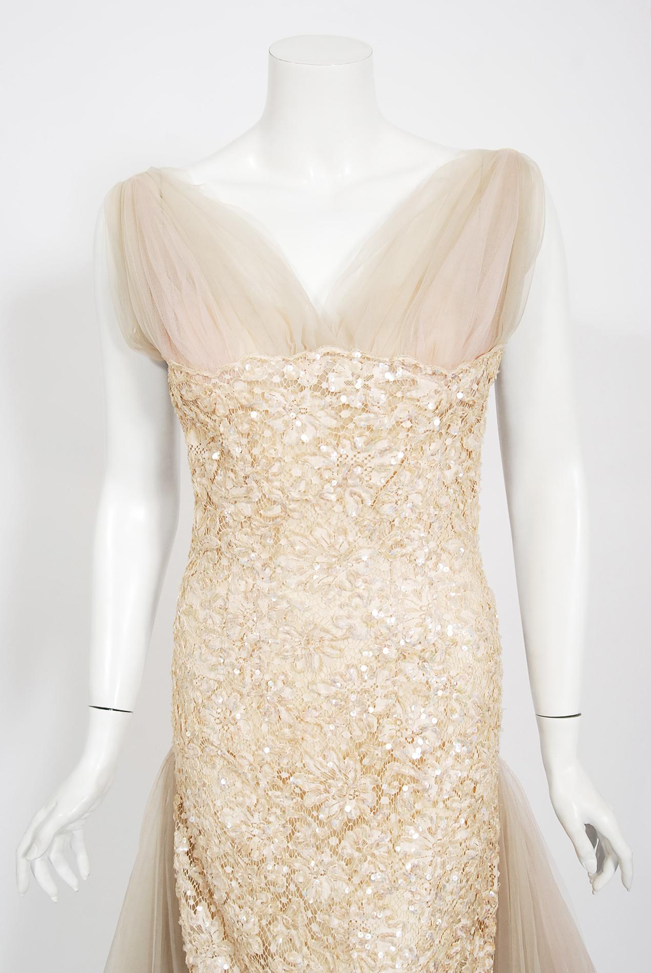 Ethereal 1950's Anne Verdi designer champagne lace hourglass cocktail dress from the Old Hollywood era of glamour! The fabric itself is a masterpiece; high-quality floral motif lace that is beautifully accented with shimmering iridescent sequins.