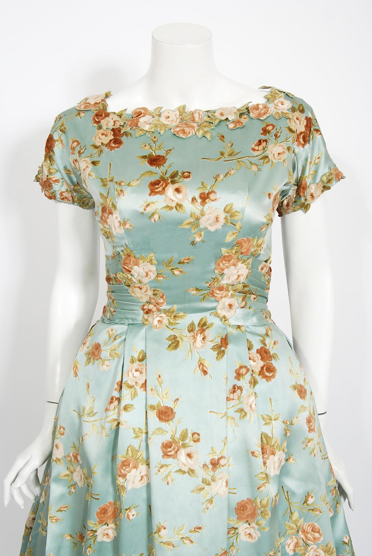 In this gorgeous 1950's baby-blue rose print silk satin gown, the detailed construction and meticulous attention to detail are comparable to what you will find in modern couture. This captivating garment is fashioned with a built-in petticoat in the