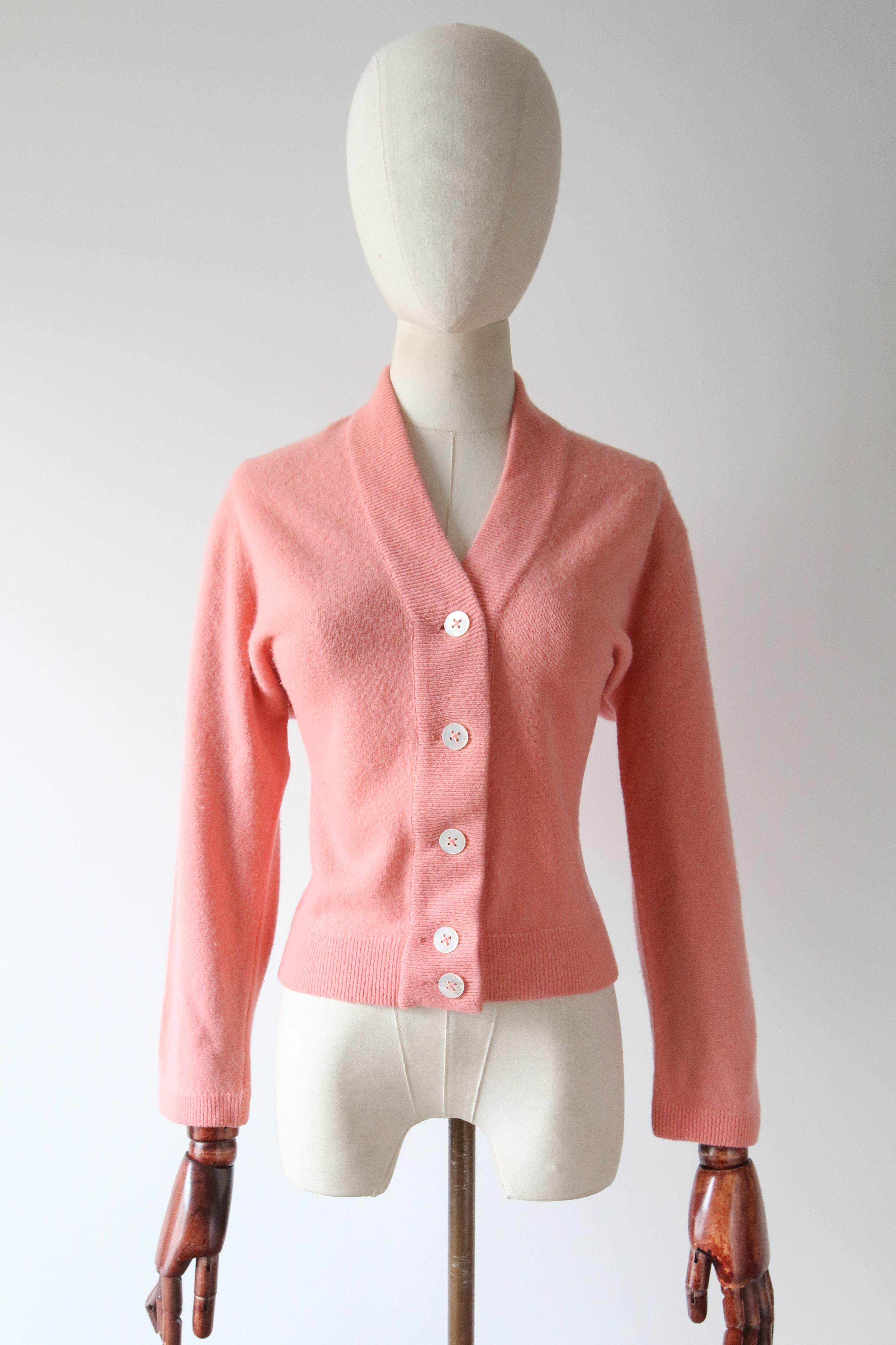 Rendered in the softest of cashmeres in an ever feminine shade of blush, this original 1950's cardigan, is the perfect piece to add yo your timeless collection.  

The V shaped neckline is framed by a ribbed border, which contours the neckline,