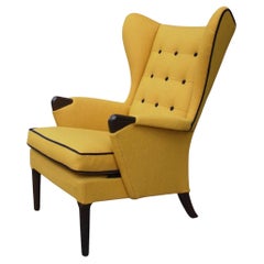 Used 1950s British wingback armchair upholstered in quality  yellow textile