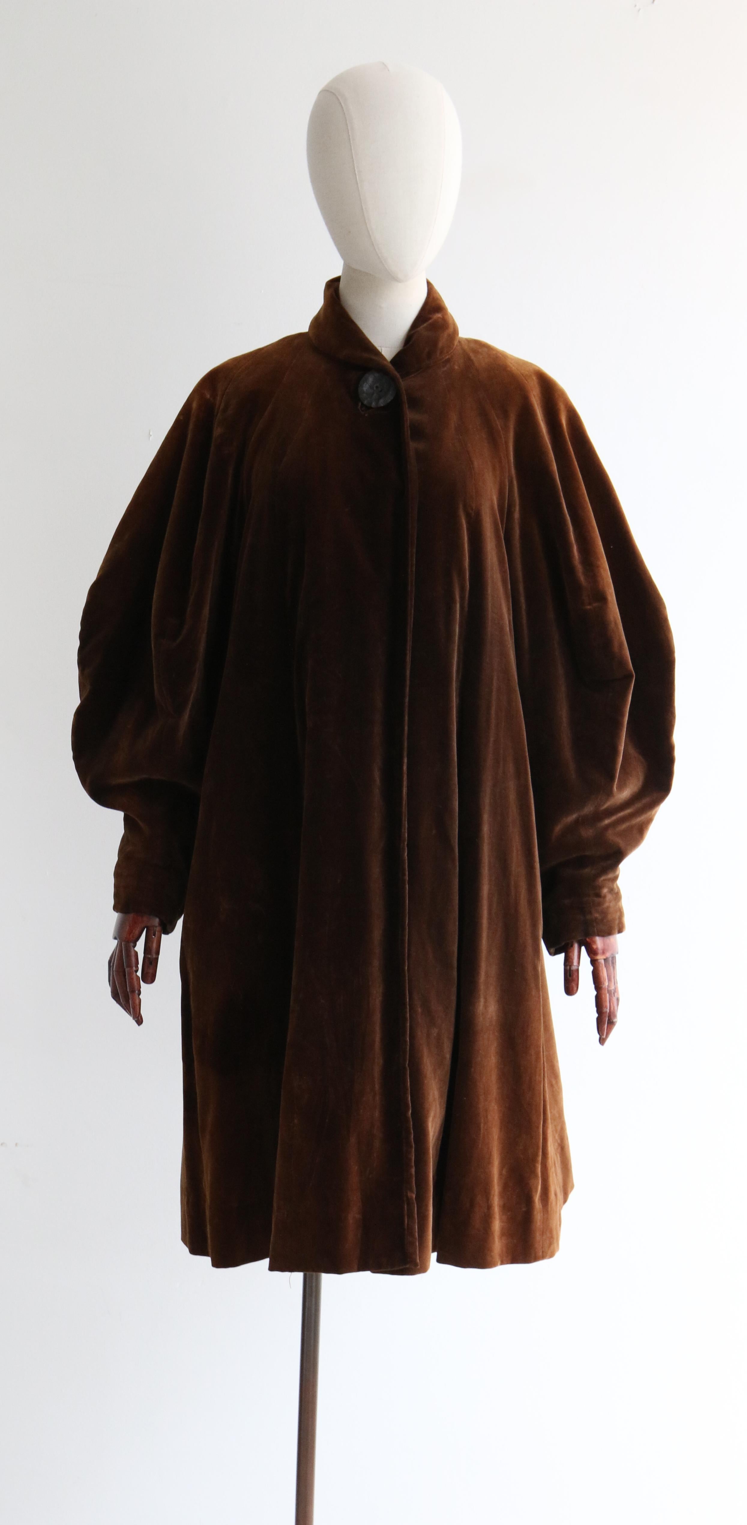 This breathtaking 1950's chocolate brown velvet swing coat, lined in brown silk taffeta is a timeless piece and an iconic number to add to your vintage collection.

The turned down shawl collar draws together along the centre front of the coat with