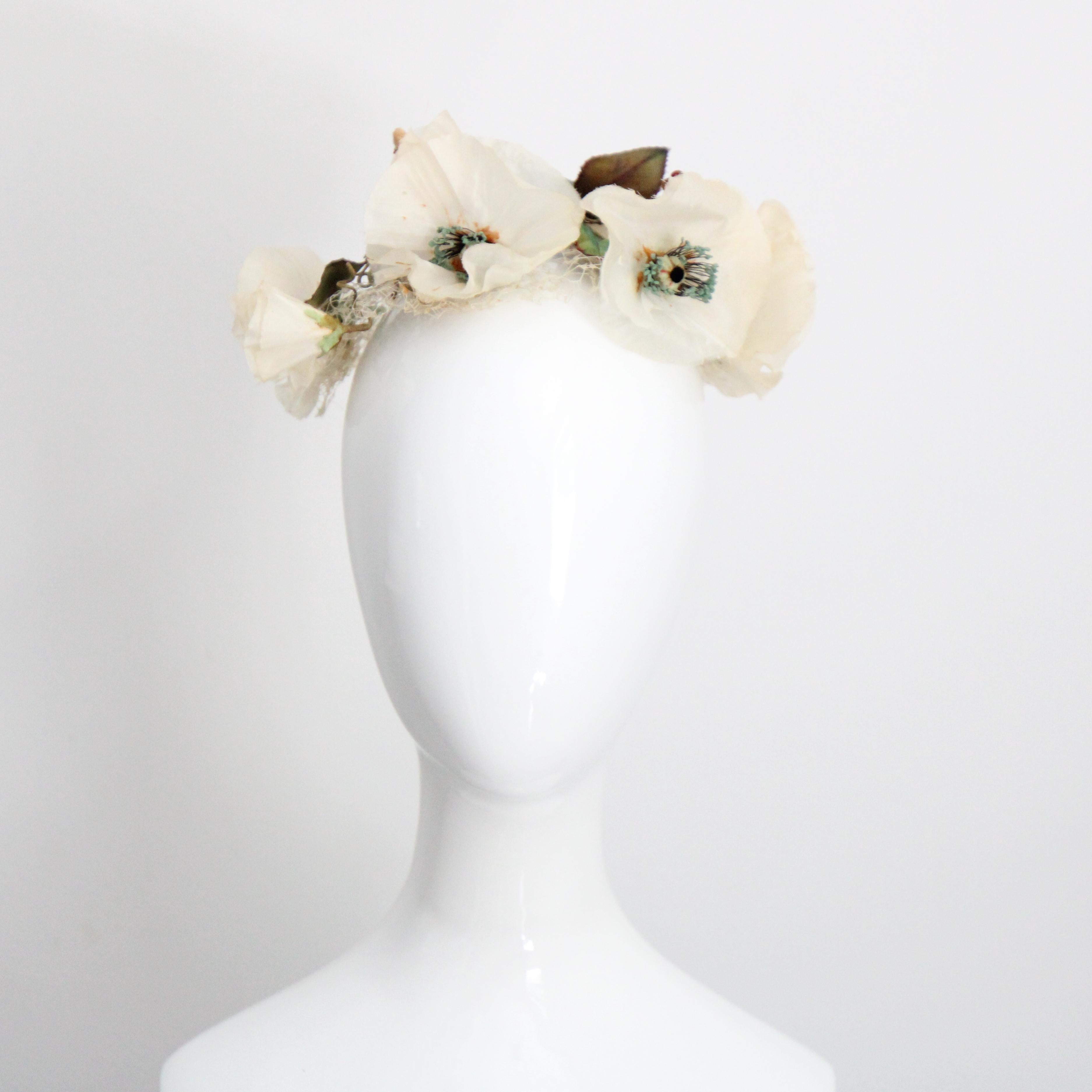 Rendered in the most sumptuous shades of cream and green, with subtle turquoise accents, this original 1950's hat, decorated with ivory anemone millinery flowers, surrounded by leaves and trailing curled wire stems, is the perfect piece to complete