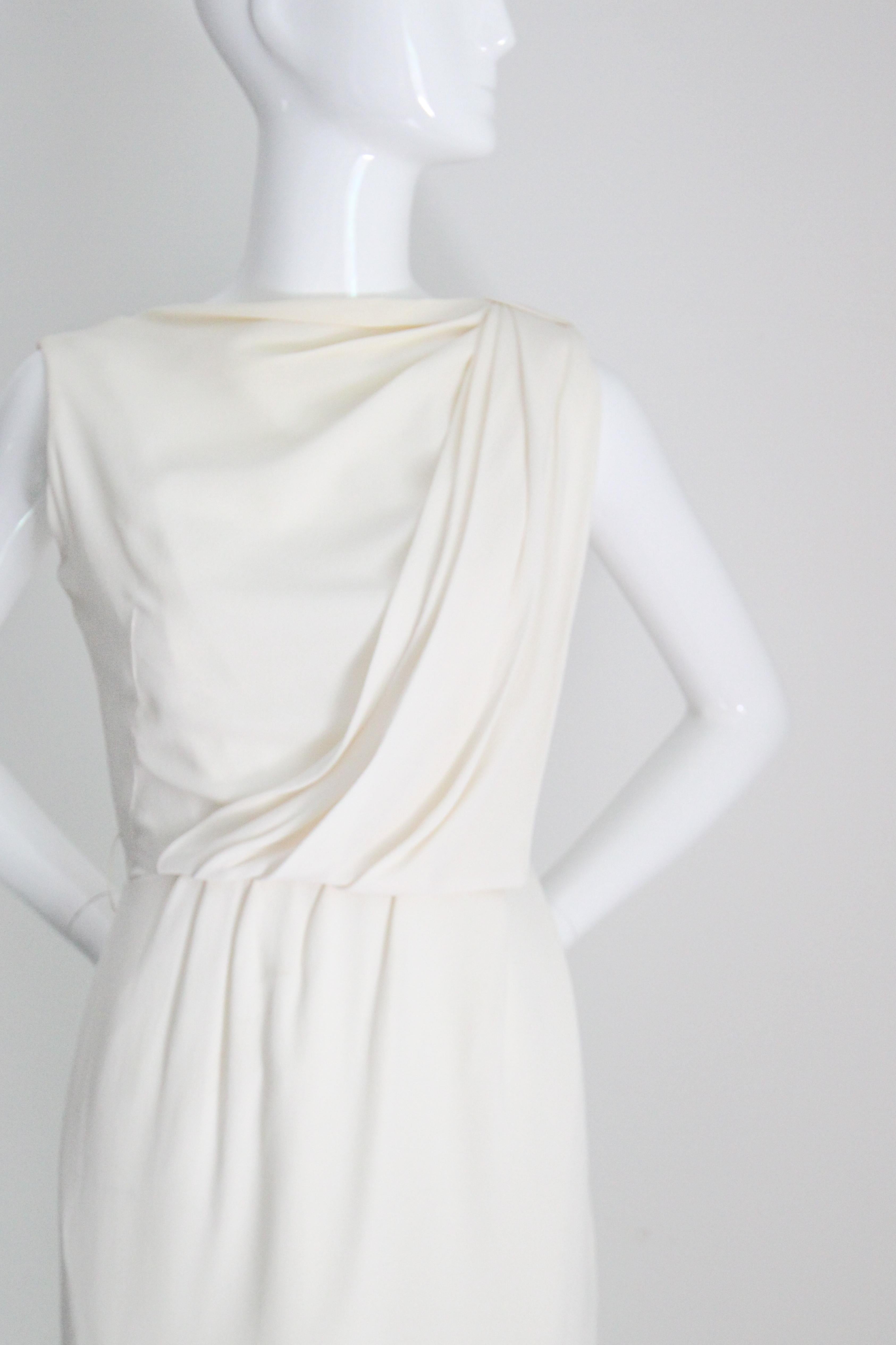 Réalisée dans une silhouette classique, cette robe crème originale des années 1950, avec de délicats détails plissés, est la pièce qu'il vous faut pour votre collection intemporelle. 

L'encolure bateau est rehaussée d'un col bénitier plissé, qui