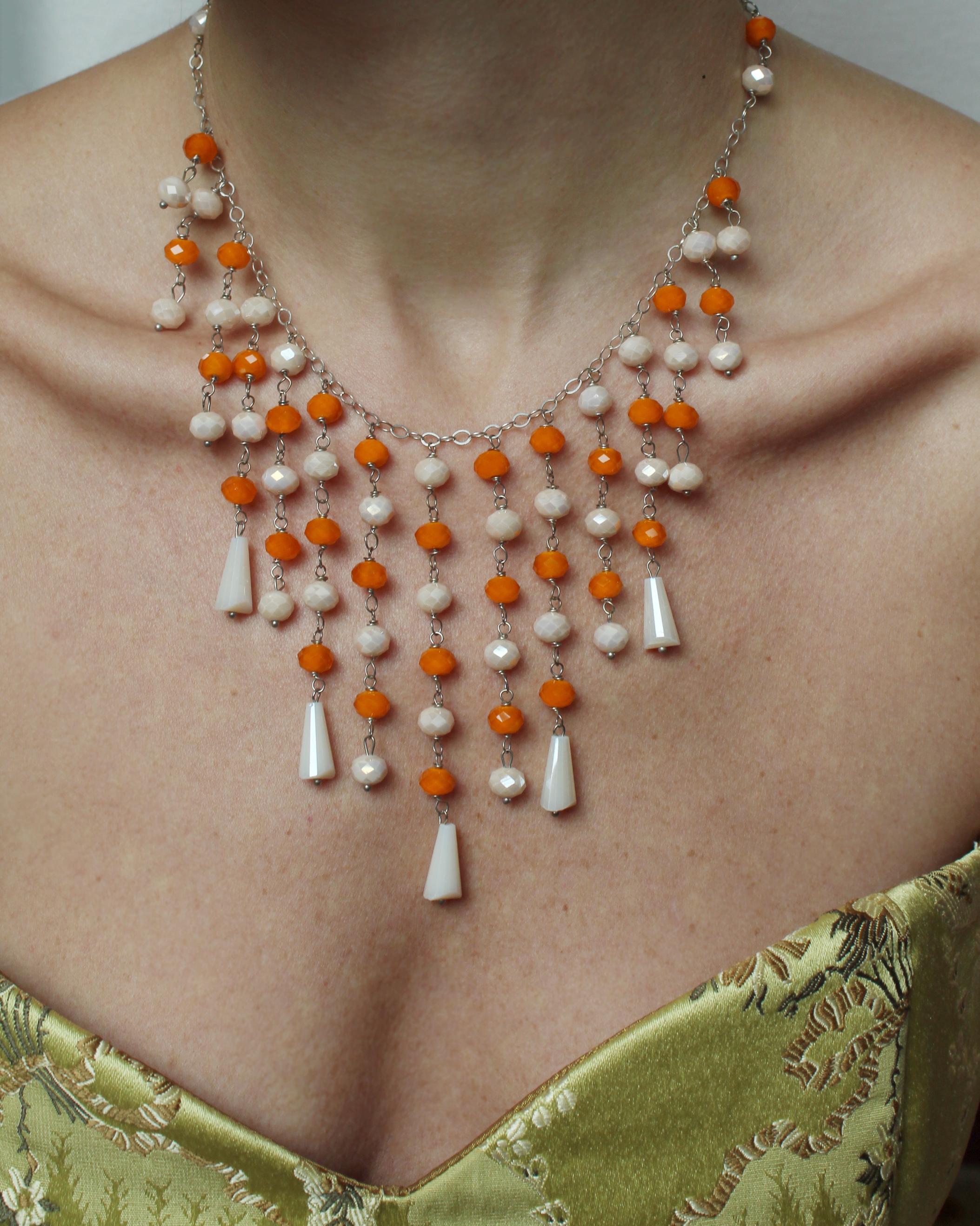 Diese wunderschöne Kristall-Wasserfall-Halskette wurde in den 1950er Jahren aus feinem tschechischen Kristall gefertigt. Die Kristalle sind wunderschön facettiert, in Orange und einem milchigen Elfenbeinton, an einer silbernen Kette - die