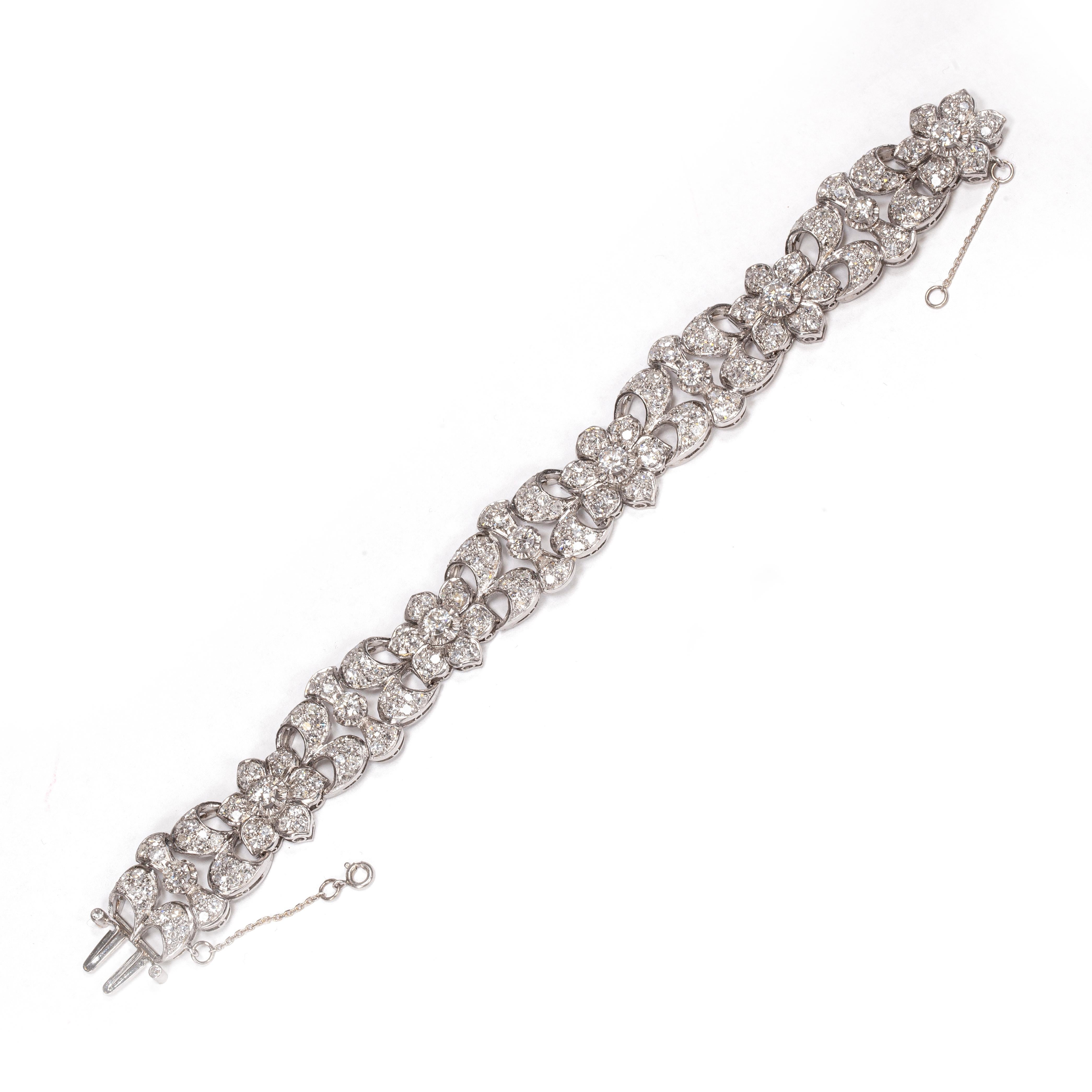 Dieses wunderschöne florale Armband aus Platin und Diamanten aus den 1950er Jahren ist wirklich einmalig. 10 Diamanten im Übergangsschliff sind in individuellen, erhöhten Fassungen gefasst, vor einem wunderschönen Hintergrund aus pavégefassten