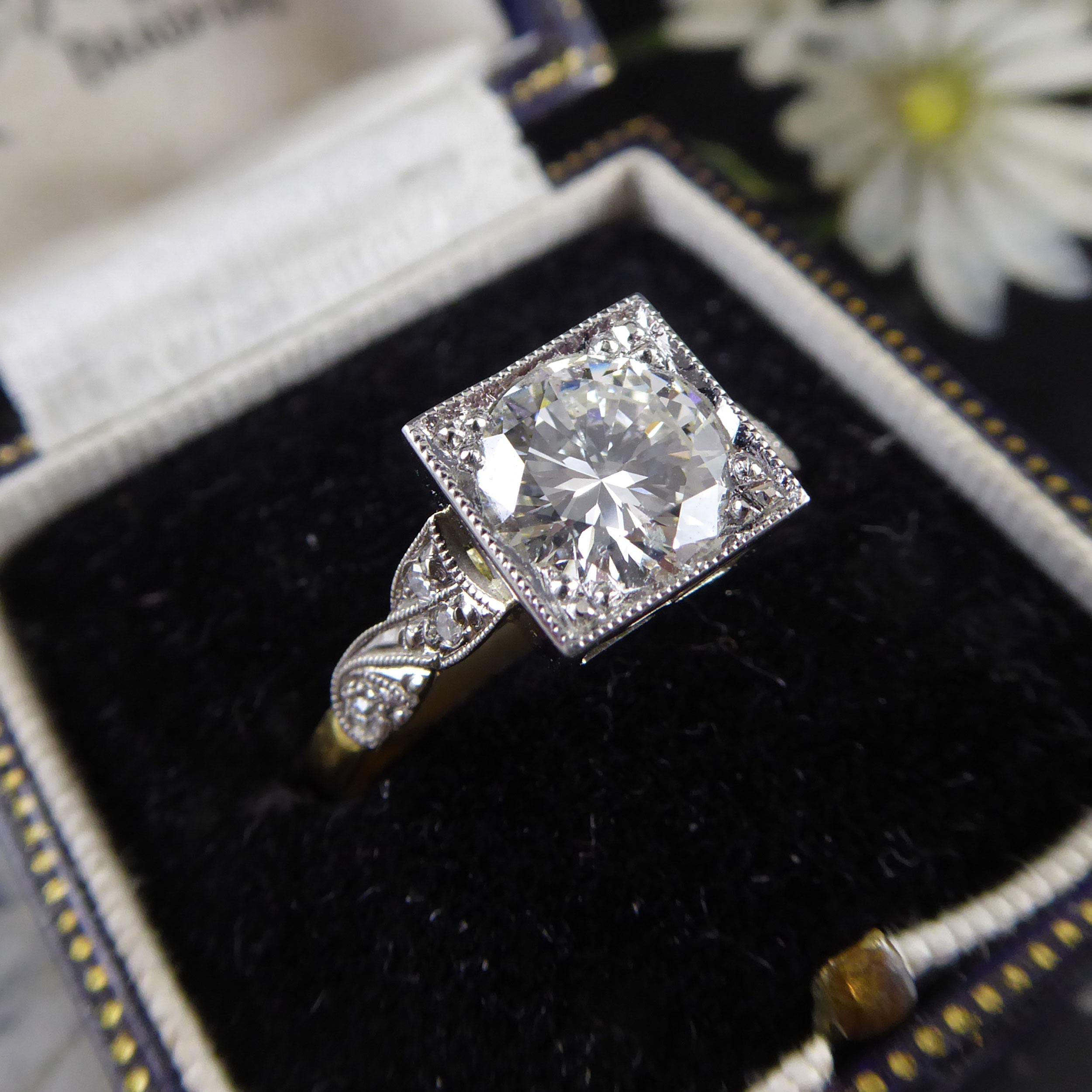 What an exquisite solitaire ring this is; a round diamond set in a square mount.  The diamond is set with four claws within a millegrain border.  The mount is open allowing the light to filter through the diamond  unhindered and has a faintly Art