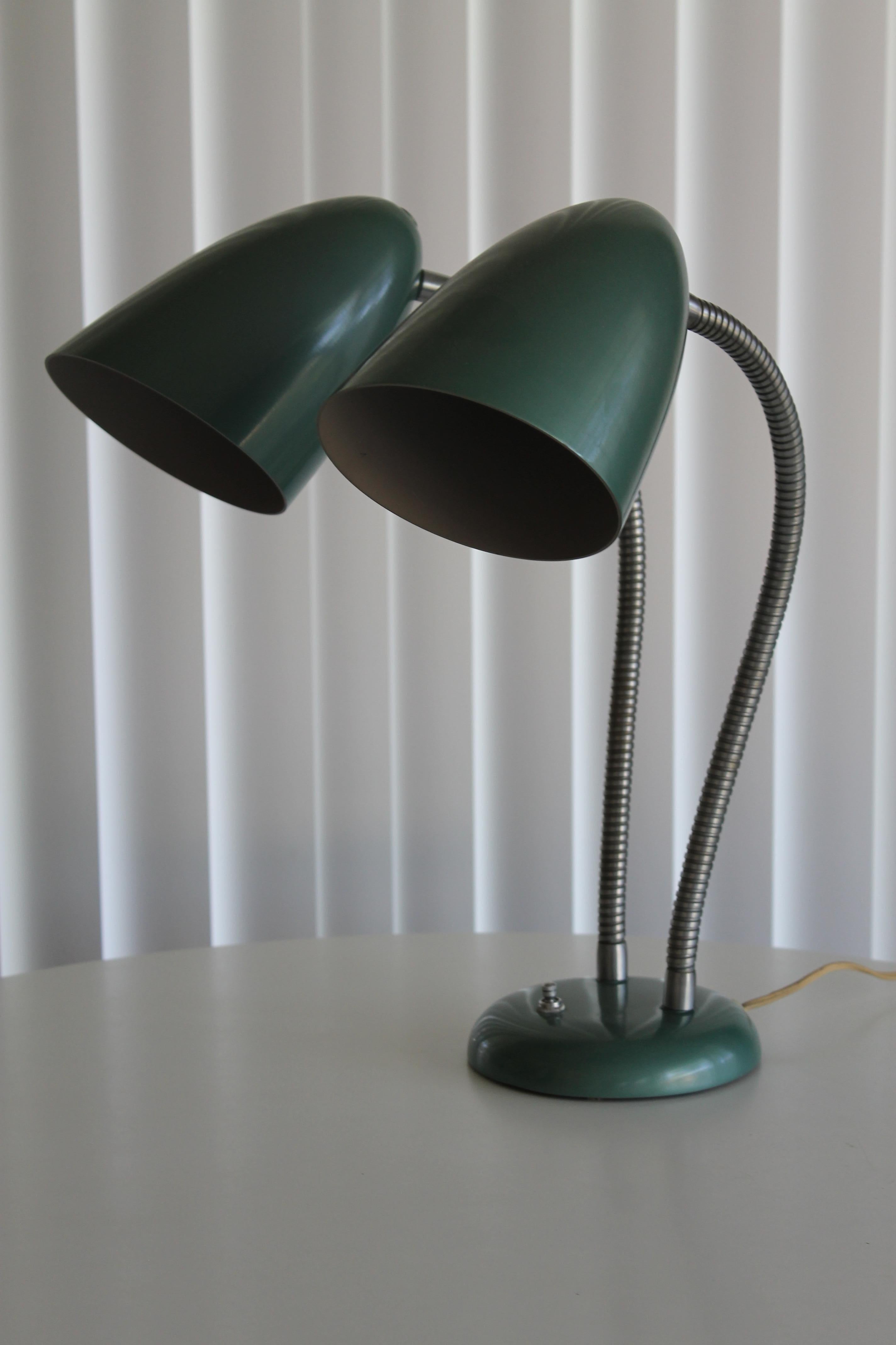 A double gooseneck desk lamp with original metallic green finish and chromed goosenecks. Lamp is in amazing original condition, with only two almost invisible scratches to the finish on one bullet cone. The turn switch on the base has a four way