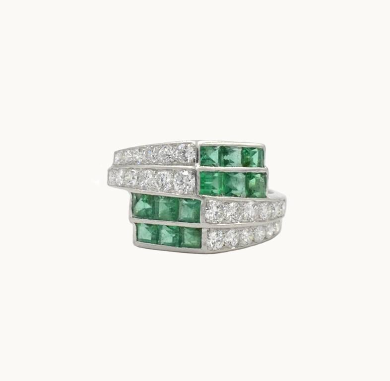 A vintage emerald and diamond platinum cocktail ring from circa 1950s.  This beautiful ring features 12 square emeralds and 24 transitional brilliant cut diamonds.  The approximate total diamond weight is 0.88 carats.  

Currently a US size 4.75 and