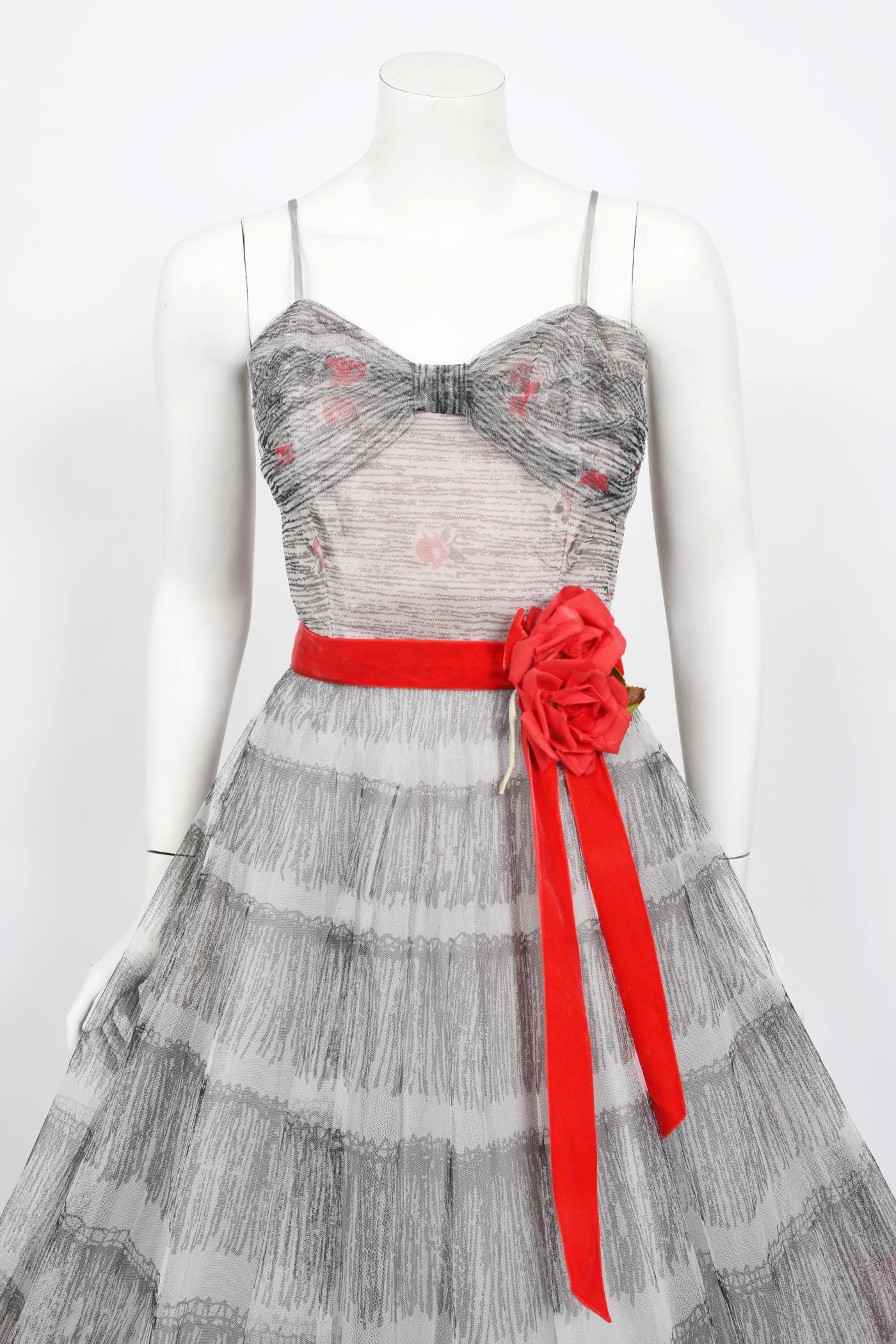 An absolutely sensational Emma Domb red roses floral tulle full-skirt party dress dating back to the mid 1950's. This figure flattering silhouette was inspired by Christian Dior's 'new look' and was extremely popular during this time period. Emma