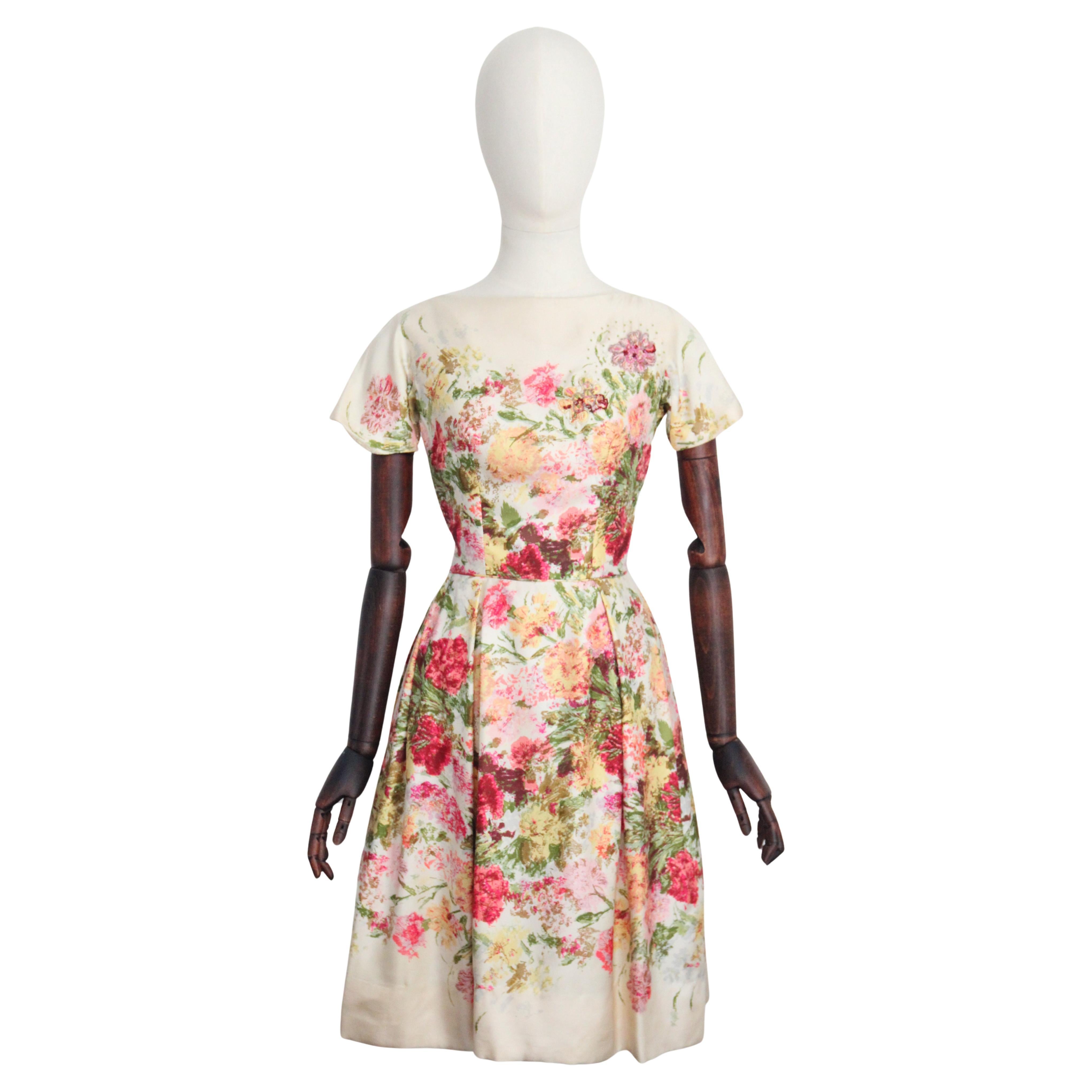 A beauty to behold, this original 1950's twill silk dress, with a wonderful sketched floral design in shades of pink, green, teal, blue, yellow, orange and lilac, set against a cream base and accented by glass beadwork, is just the piece to add to