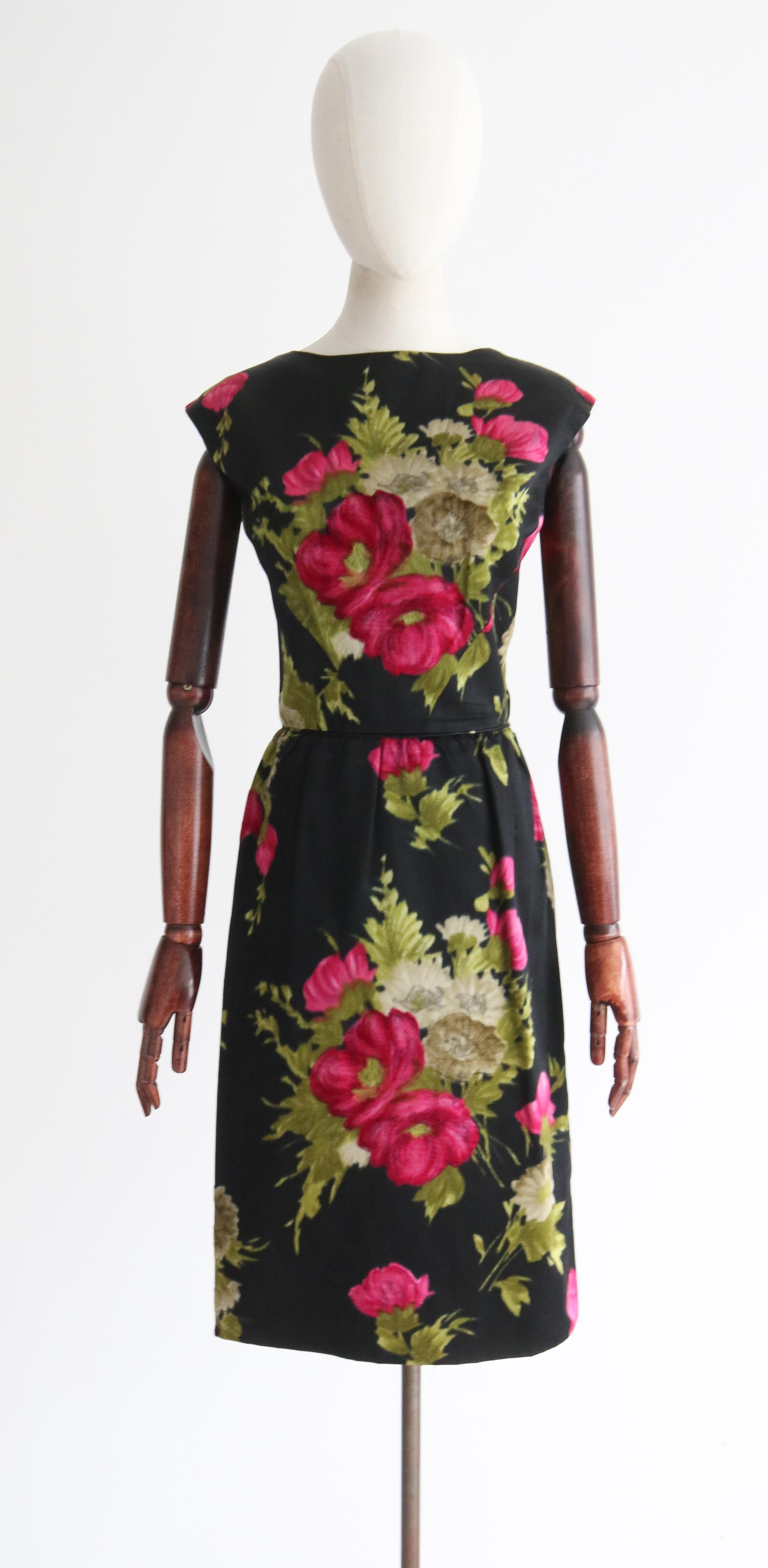 Rendered in the most sumptuous black and floral satin with silk velvet flocking accents, this original 1950's dress and matching jacket is the perfect ensemble for that special occasion . The bold fuchsia pink silk velvet flowers and pale green
