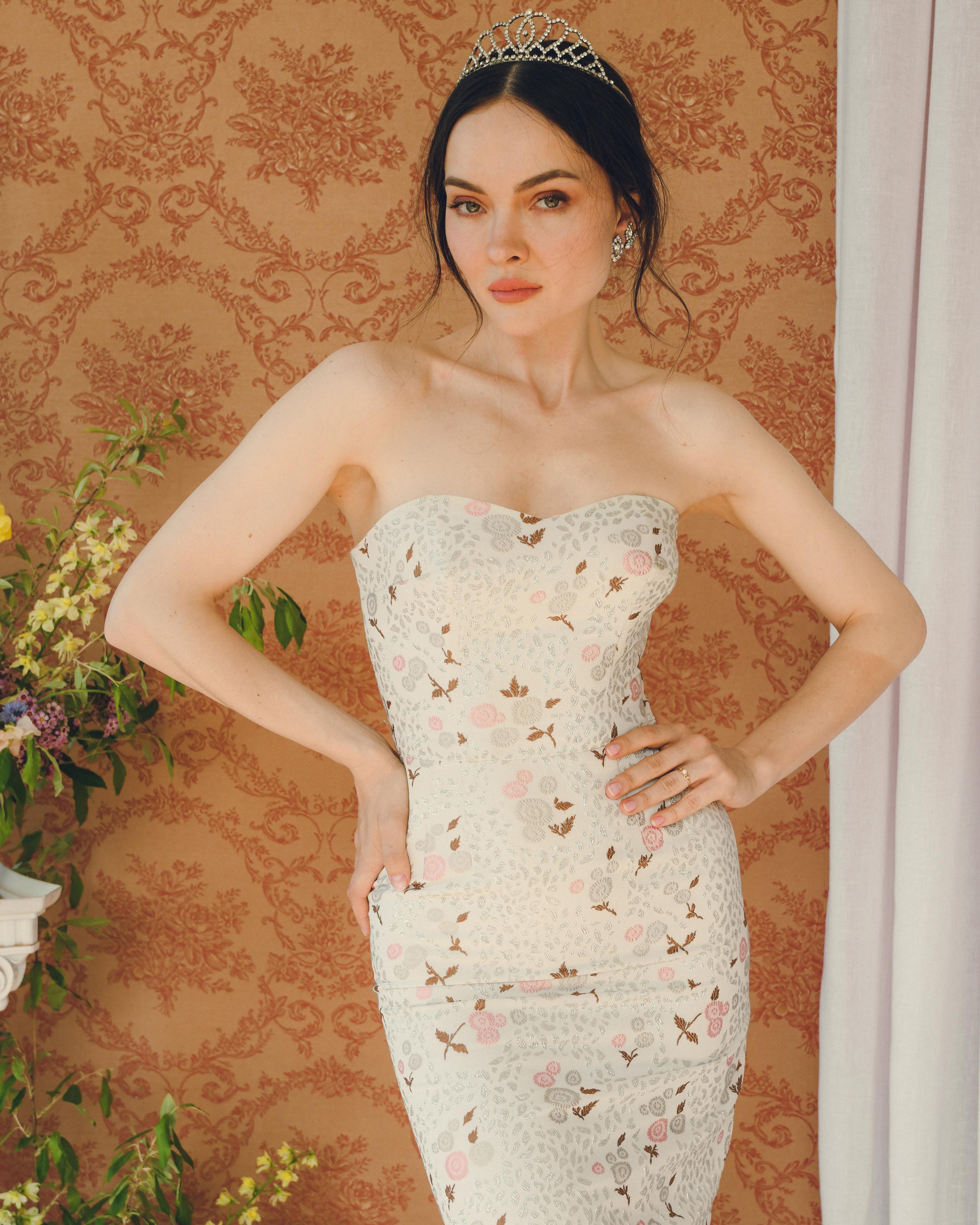 Cette incroyable et rare robe bustier à corsage déhanché des années 1950 est fabriquée dans un superbe tissu lamé floral, brodé et floqué à la fois de broderies mates et de fils métalliques, pour un aspect très riche et multidimensionnel. Cette robe