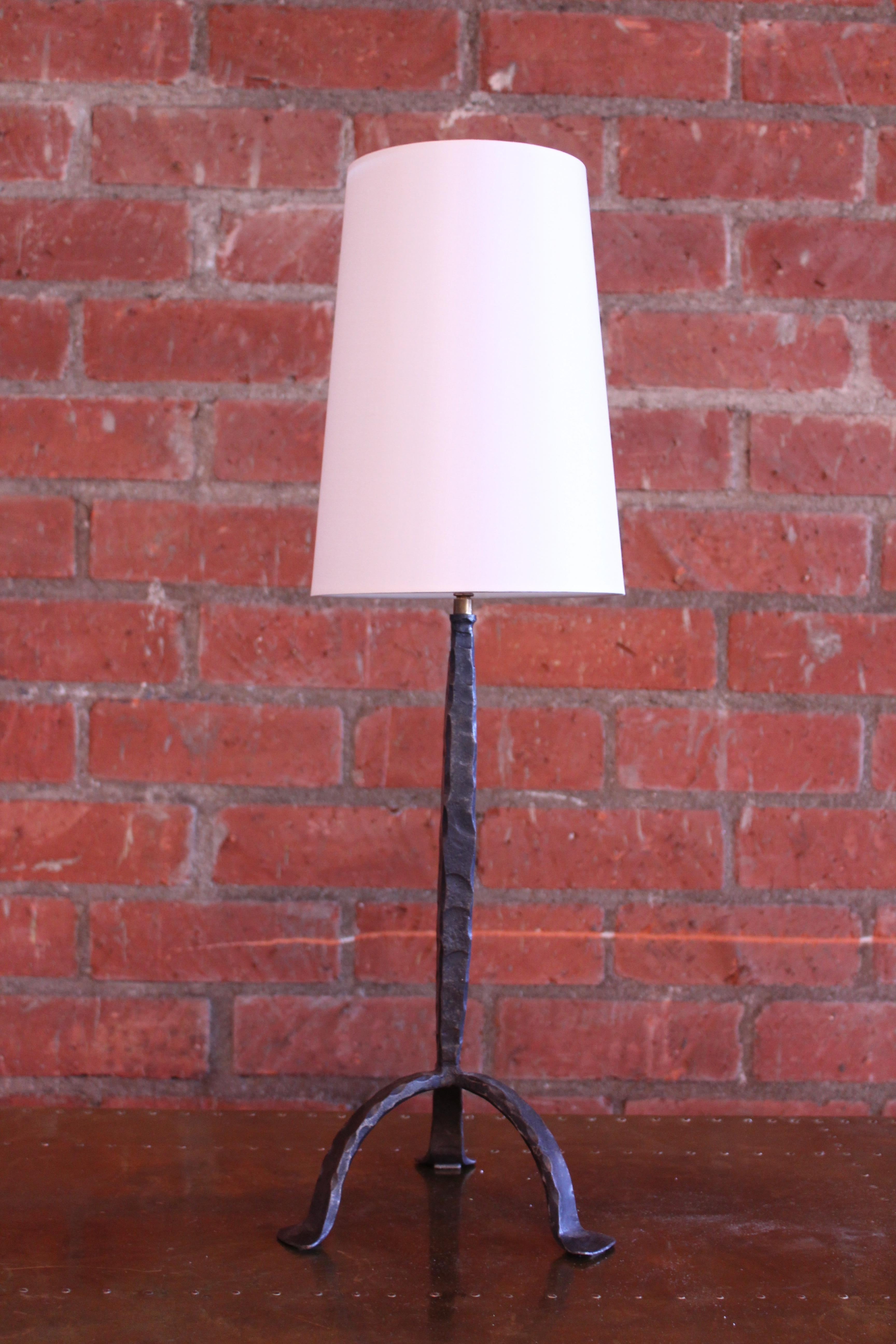 Vintage solid forged iron French table lamp. Newly rewired in brown twisted silk cording with a custom made shade in silk. Click switch on cord and French wired for U.S standards. Uses a standard candelabra bulb. Measures: 27.75