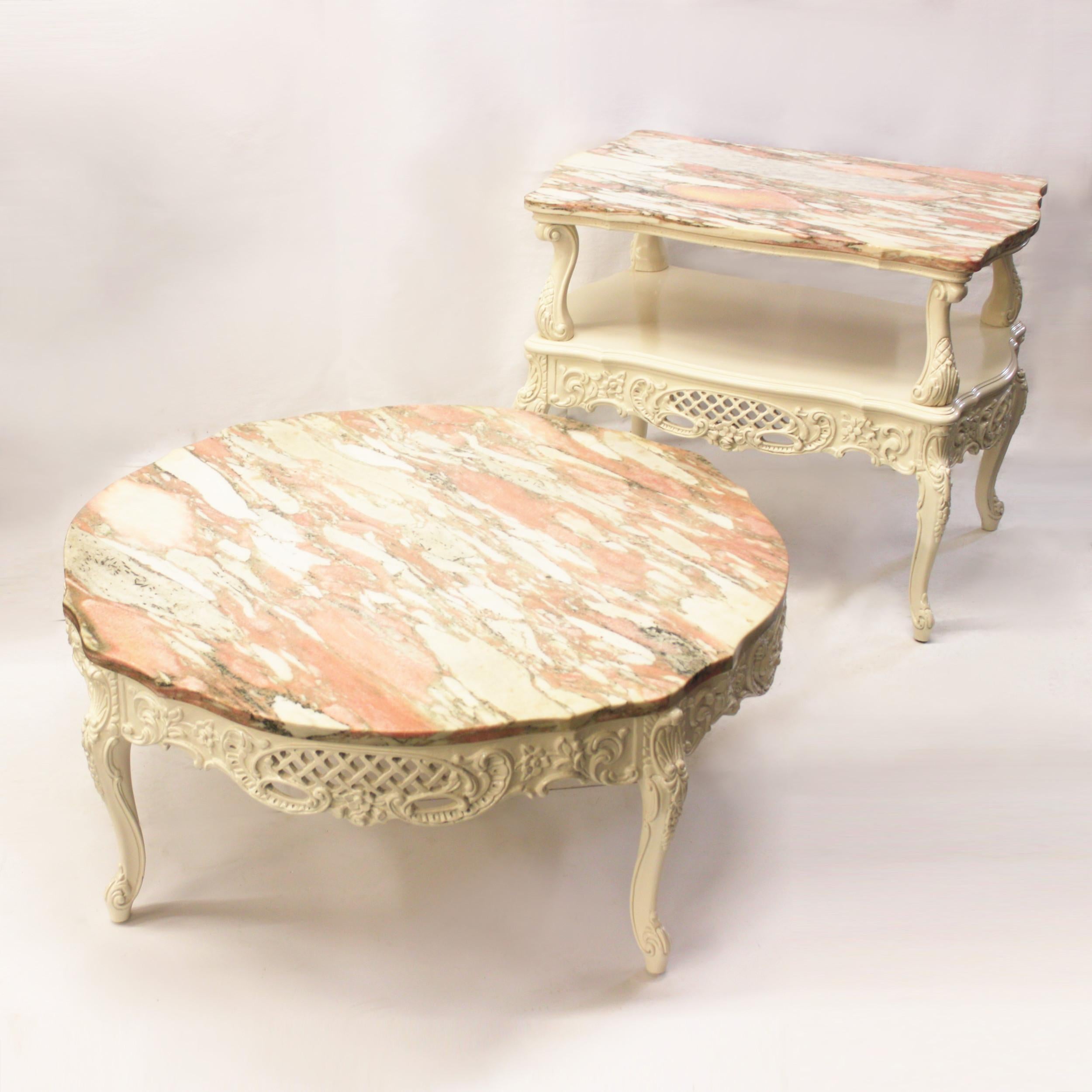 Wonderful pair of vintage 1950s French Provincial style tables. Tables feature intricately carved, solid wood bases with a fresh coat of off-white enamel paint. Marble tops are in excellent condition and are cut to perfectly mimic the shape of the