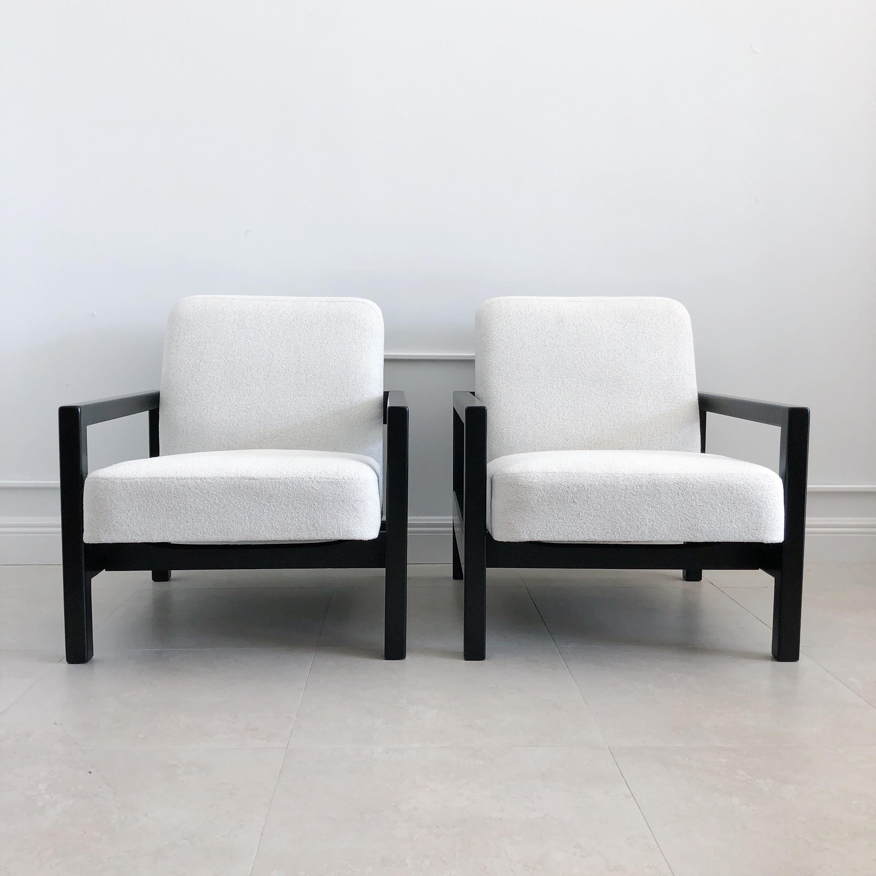 Designed by George Nelson for Herman Miller, these rarely seen armchairs, model 4774, feature an open rectilinear frame in ebonized birch and a deeply comfortable upholstered seat and back. These have been newly reupholstered in boucle fabric, with