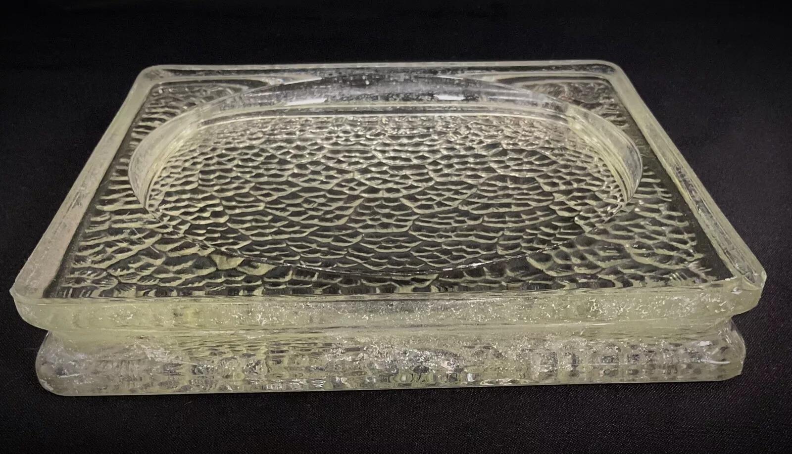 This vintage 1950s glass tile by renowned designer Jacques Adnet is a striking addition to any interior decor. Measuring 7.7 inches (19.5 cm) in both length and width, this single tile features a beautiful textured surface with an intricate circular