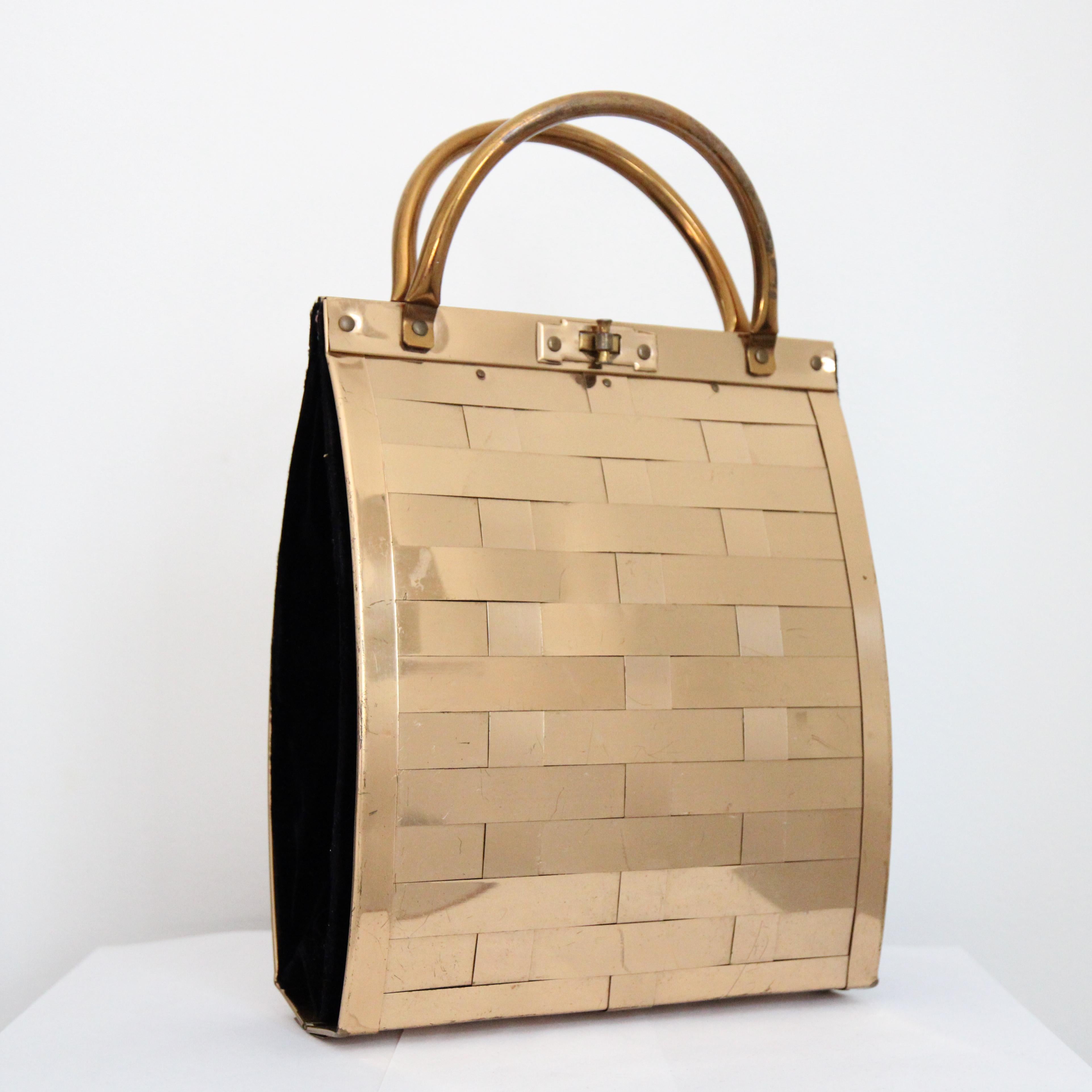 This beautiful 1950's Dorset Rex tall curved rectangular handbag, with gold toned metallic features, is the perfect finishing touch to your outfit. 

The large rectangular curved shape of the bag, boasts an exterior of woven gold strands, framed to