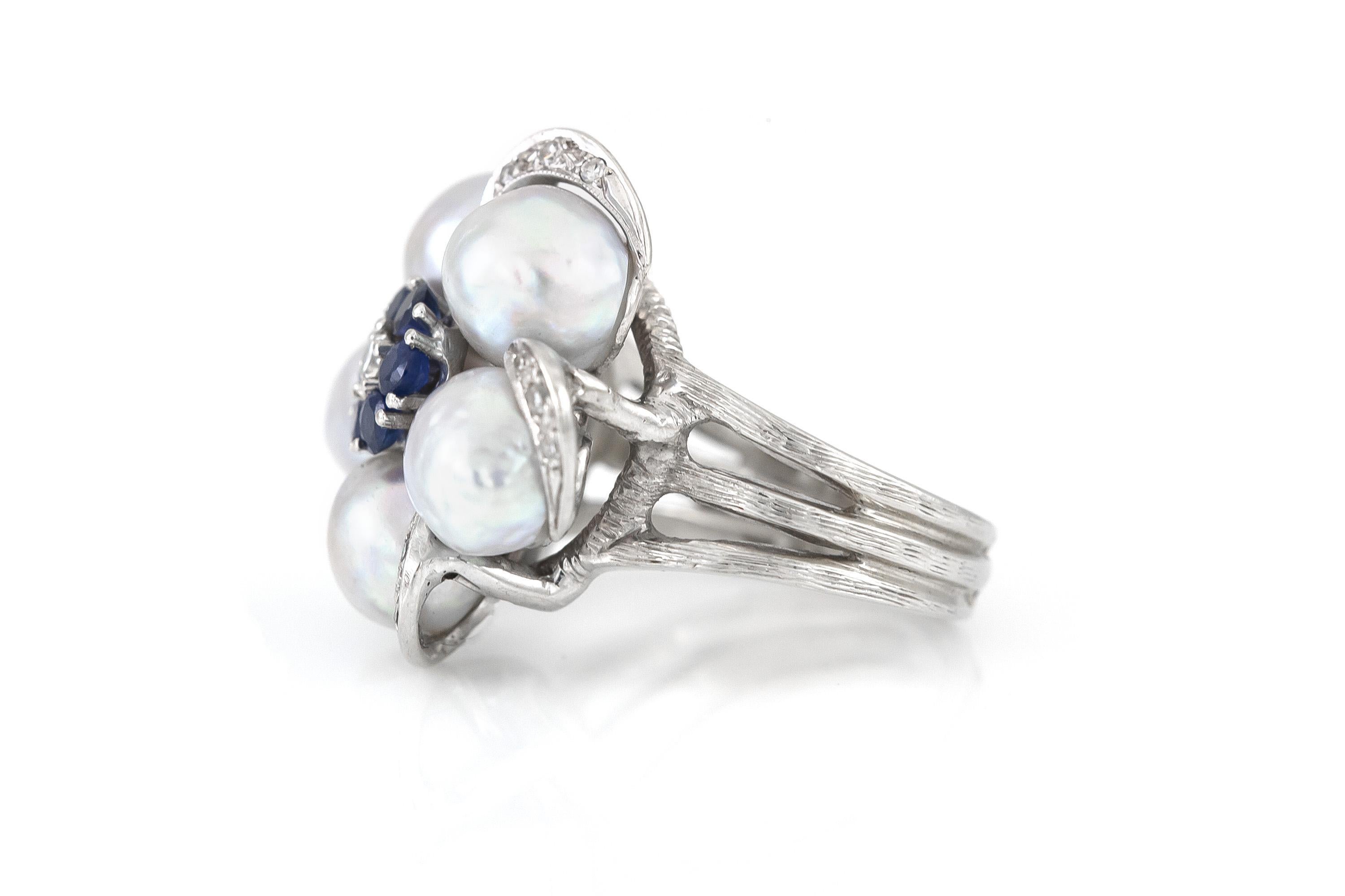 Finely crafted in 14k white gold with five Grey Rearls, Round cut Sapphires, and Round Brilliant cut Diamonds.
Circa 1950s
Size 7, resizable