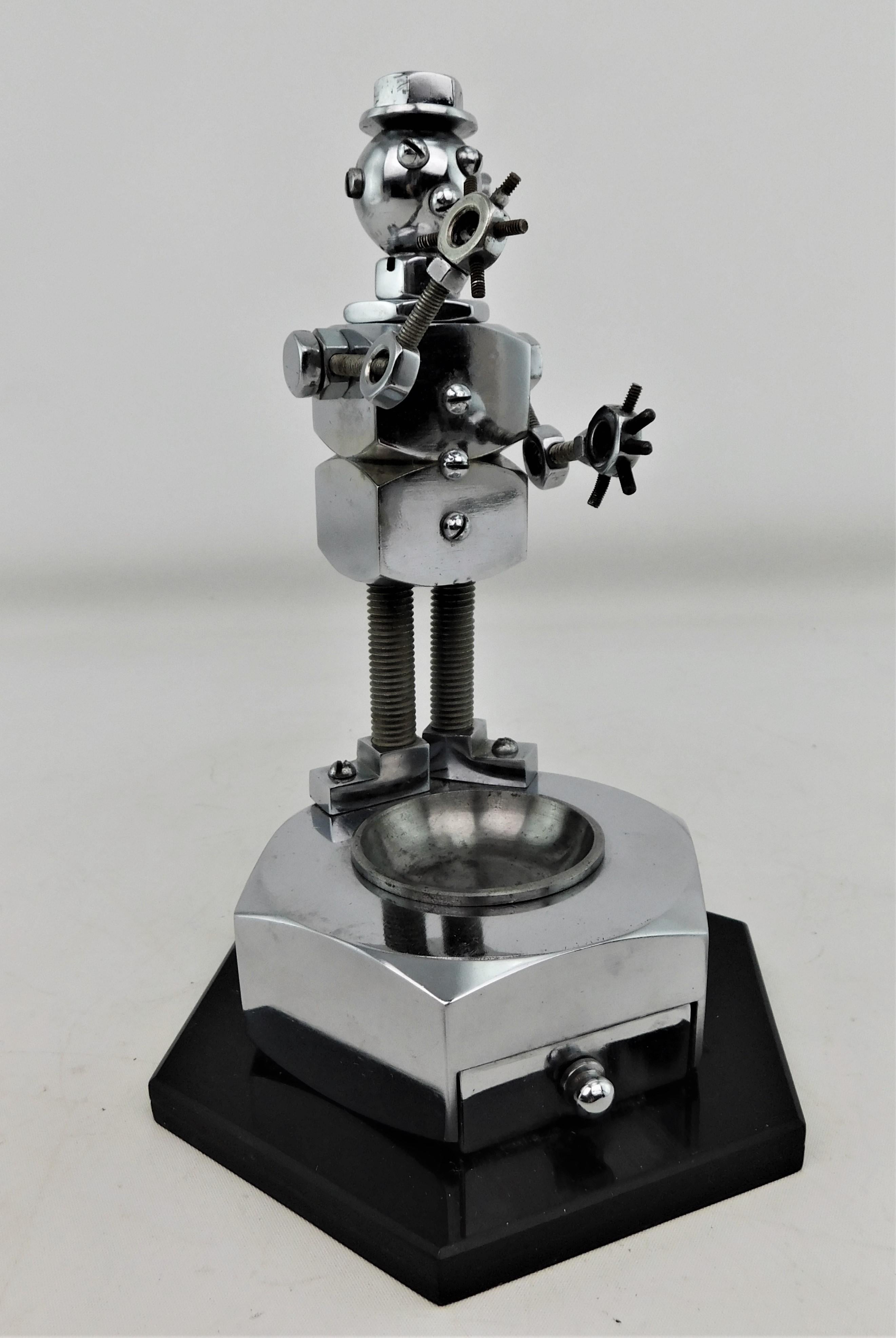 Vintage One of a kind 1950s handmade metal Robot ashtray with articulating arms, pullout drawer and ash tray that comes out to be cleaned. On a hard plastic acrylic five angled Pentagon base 6 inches round by 8.75 inches high.