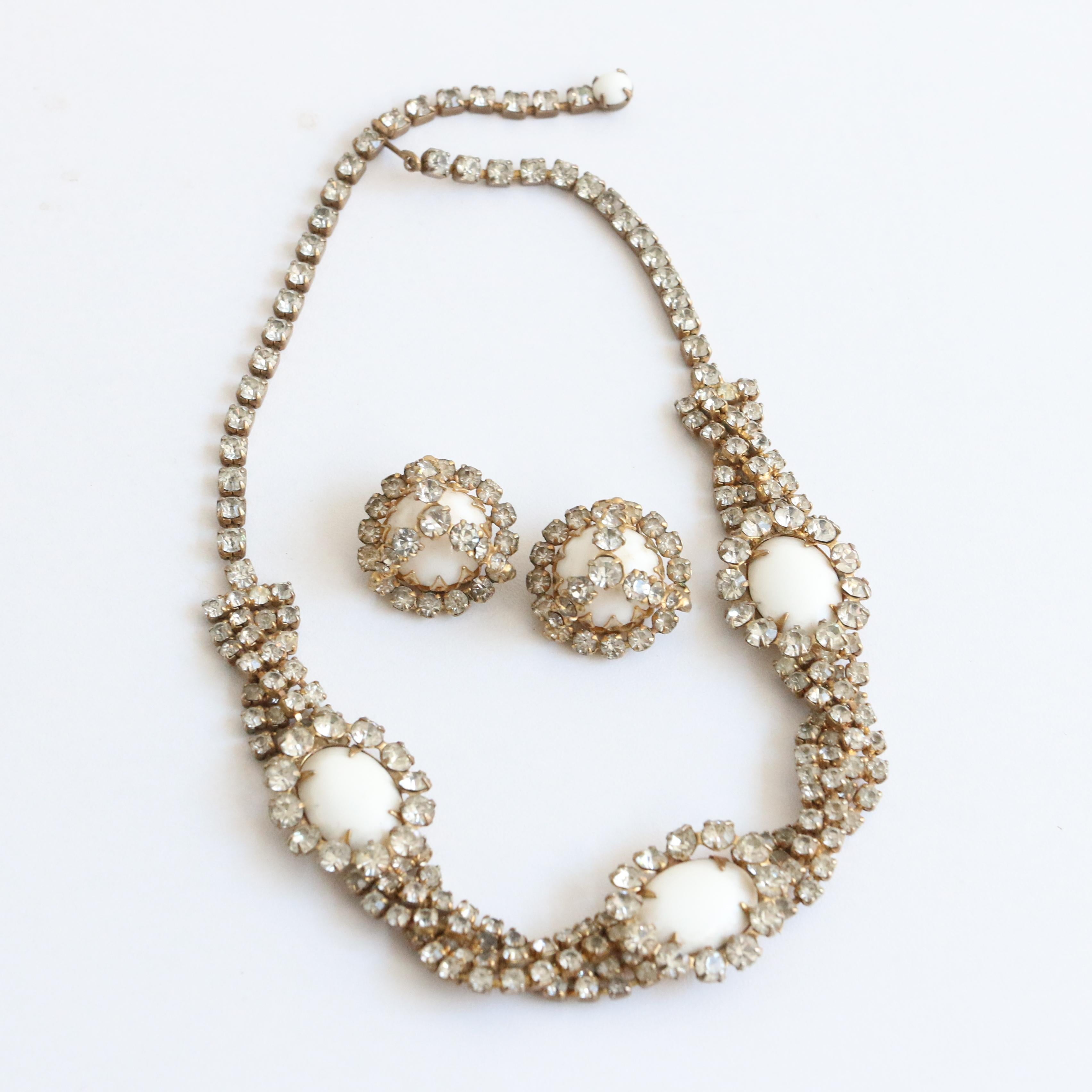 Dieses atemberaubende Schmuckset von Hattie Carnegie aus den 1950er Jahren, bestehend aus einer Halskette und Clip-Ohrringen, ist das perfekte Set, um Ihrem Outfit einen Hauch von Glamour zu verleihen. 

Die verschlungene Halskette hat ein
