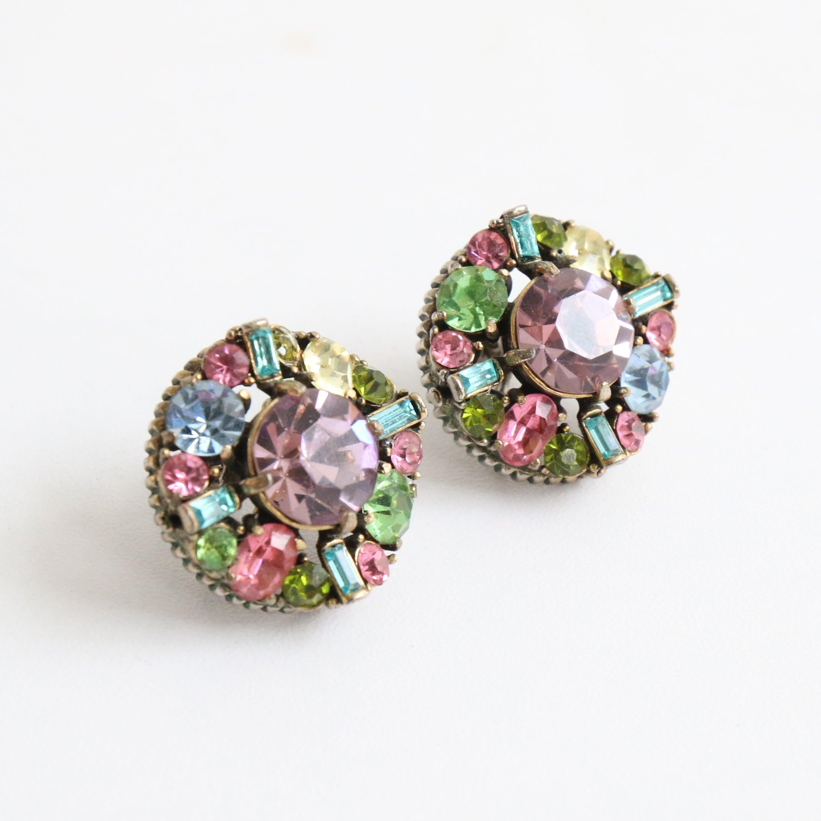 This sparkling pair of 1950's screw back earrings, made up of a central claw set lavender rhinestone surrounded by  oval, round and baguette rhinestones in a pastel palette of blue, pink and green are the perfect finishing touch to any