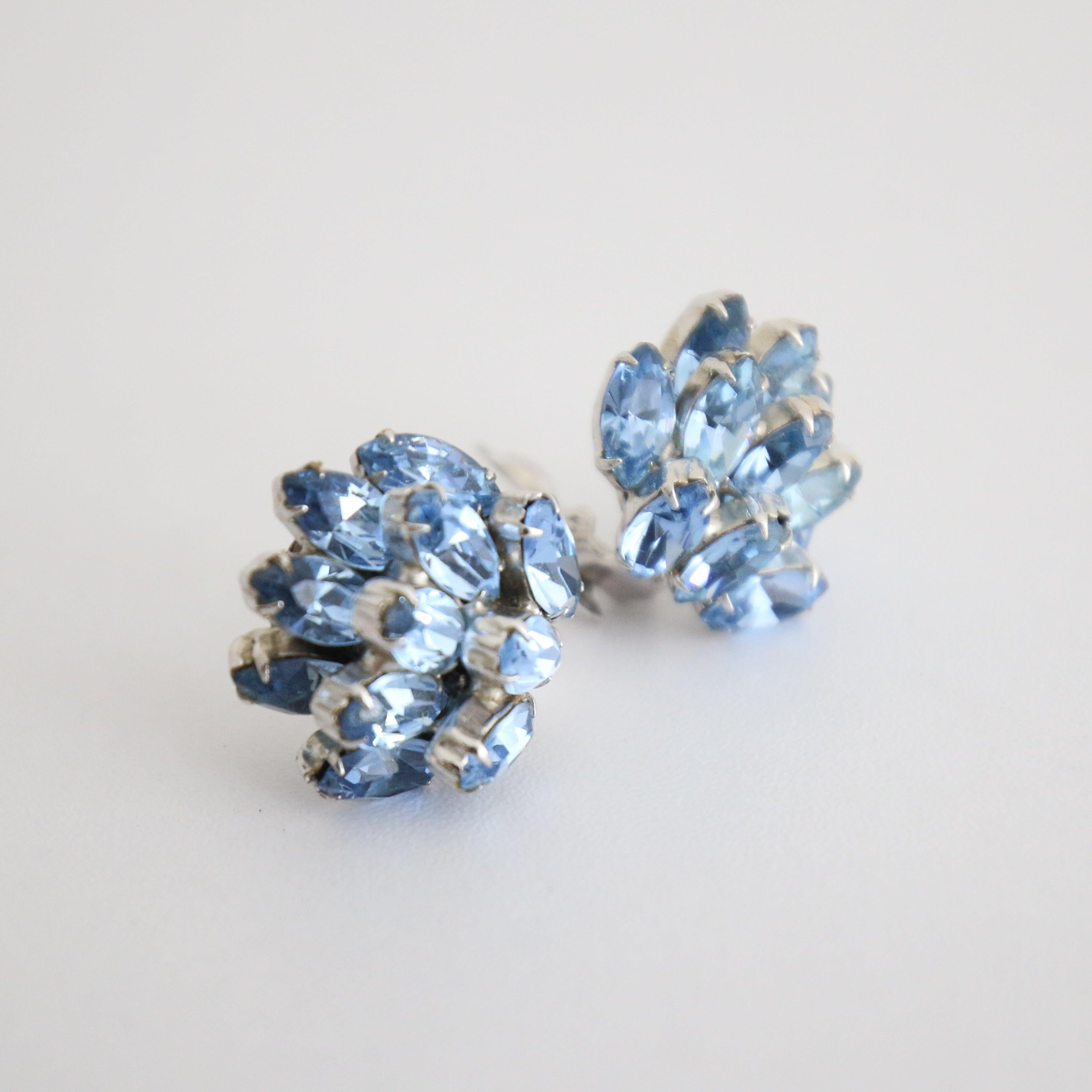 This breathtaking pair of 1950's clip on earrings, on silver toned metal bases, made up of claw set ice blue petal rhinestones in a tiered botanical design are the perfect touch of sparkle to your outfit. 

Length: 0.9 inches

Width: 0.9