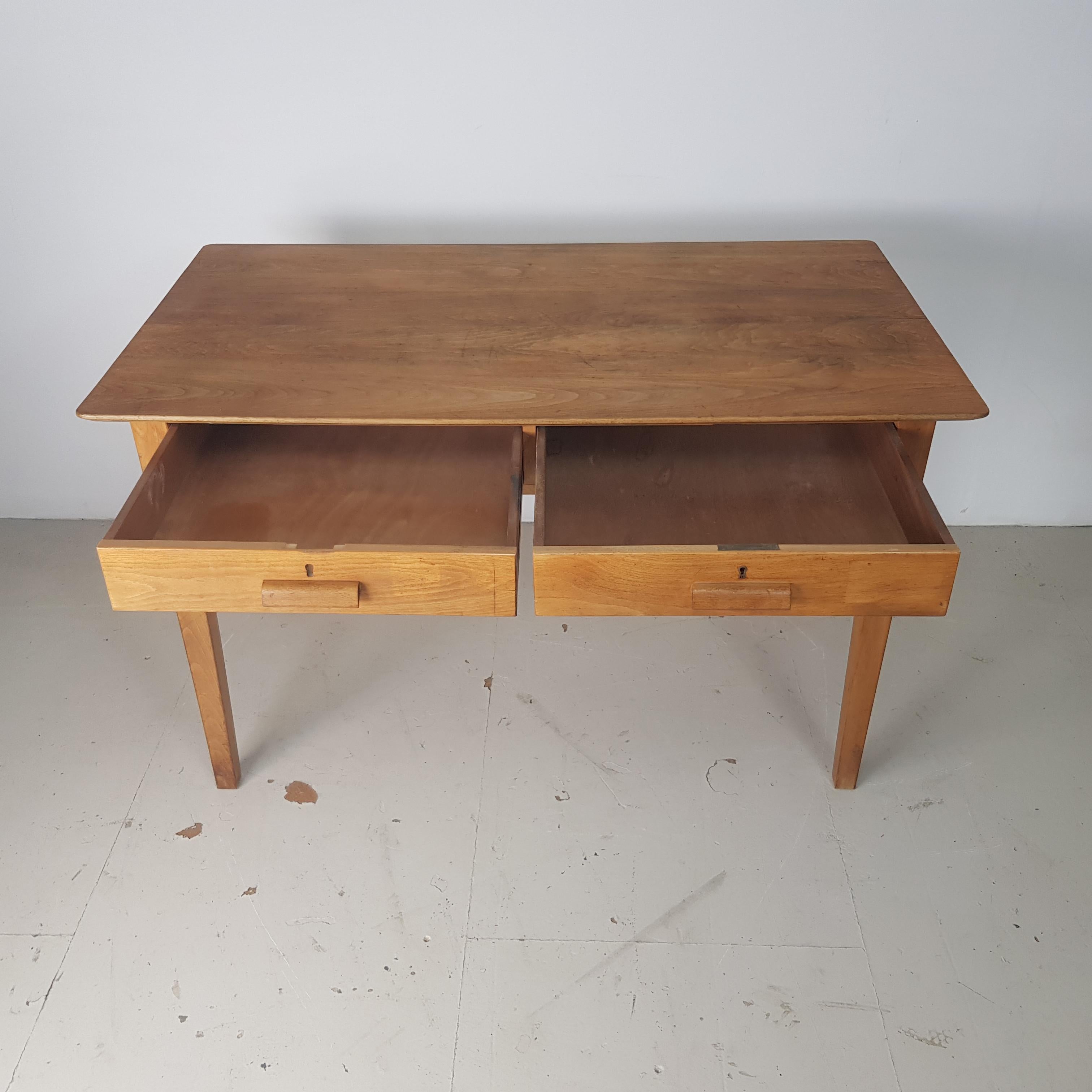 2 drawer beech Esavian desk from the 1950s, with original wooden handles.

Approximate dimensions:

Height: 76cm

Width: 122cm

Depth: 69cm

Drawers: 47cm W x 48cm D x 8cm H.

Knee height 61cm.

In good vintage condition, with marks as