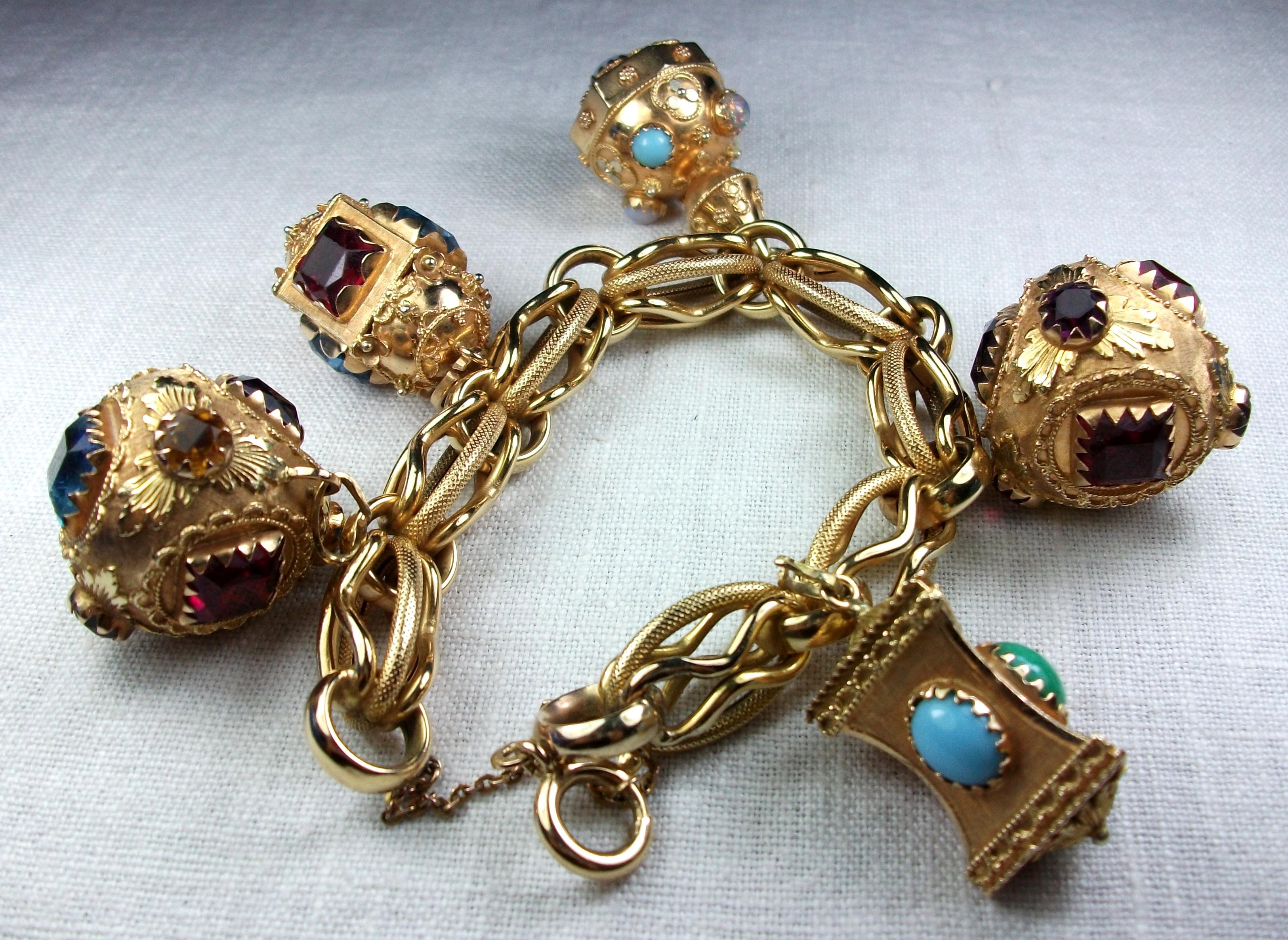 This is a more than wonderful 18k Etruscan style charm bracelet loaded with 5 enormous charms and weighing a substantial 130 grams. The bracelet is wonderfully worked as the charms. Charms are all worked in Etruscan style and embellished with