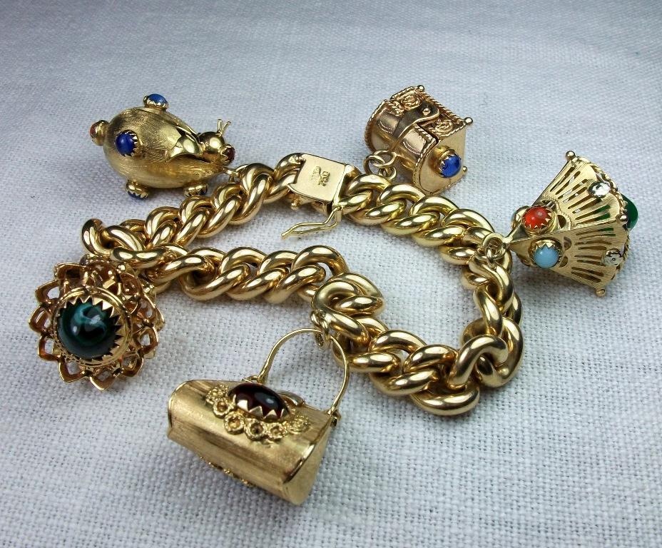 This is a more than wonderful 18k Etruscan style charm bracelet loaded with 5 big charms and weighing a substantial 45.5 grams. The charms are wonderfully worked in Etruscan Revival style and embellished with gemstones as garnets, yellow topazes,
