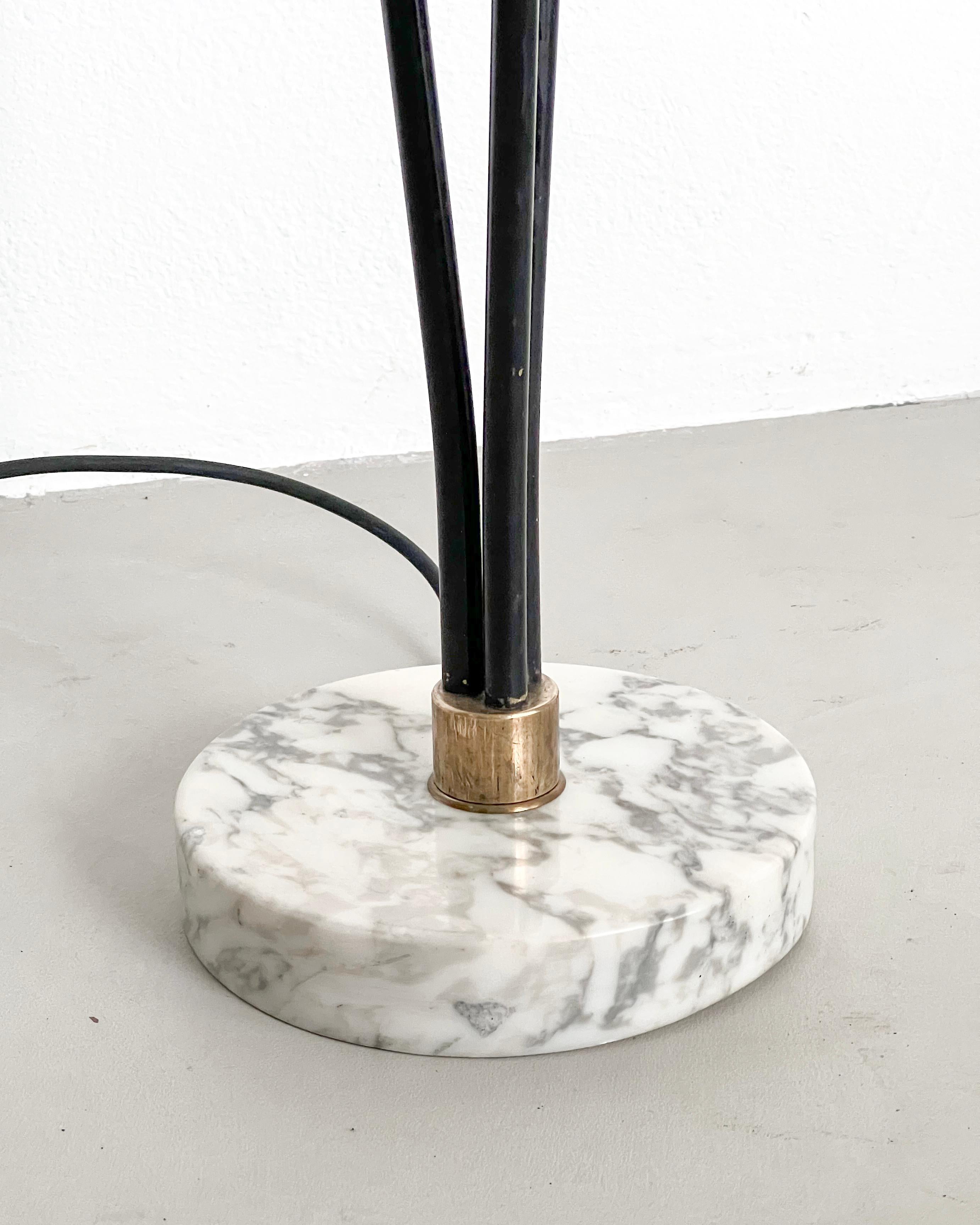 Offered for sale is a vintage floor lamp, made in Italy in the 1950s. It's crafted from metal and brass and has a round white marble base with a nice texture. It has three light bulbs, with elegantly shaped shades in white opaline glass. The three