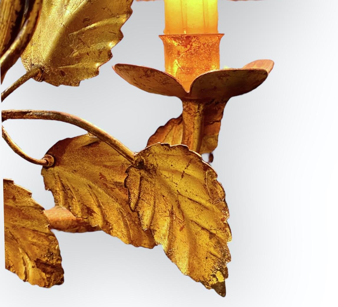 Italian Gilt Metal Floral Wall Sconce. Elaborate gold gilt iron rose and leaf pattern with two electrified candle holders with clip on pleated black silk shades. Romantic Hollywood Regency at its best for that dramatic statement. Made in Italy.