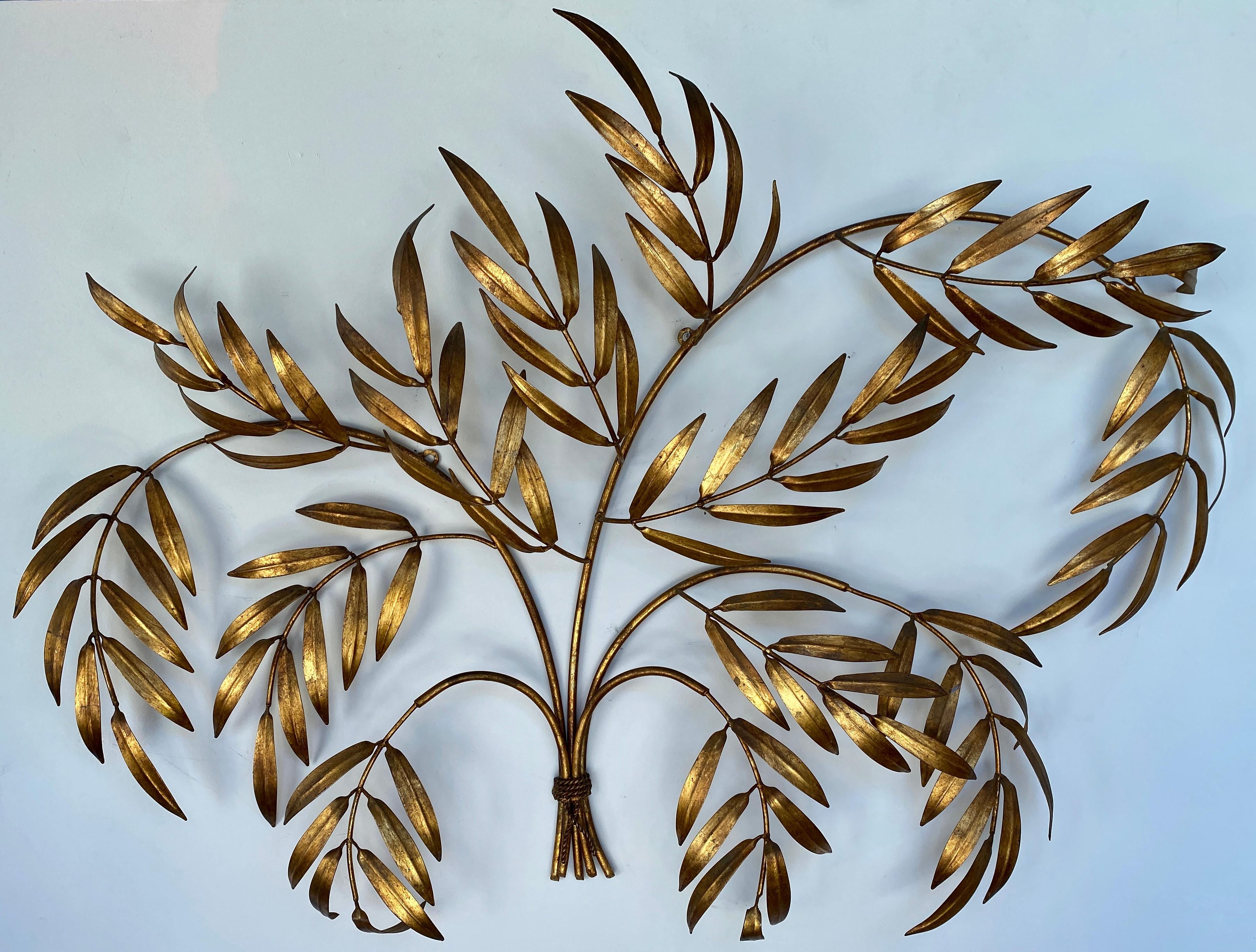 A monumental Italian gilded wall sculpture, starting from it's base of 5 branches tided together by a gilded metal cord, branches then are radiating outward that then turn into 13 branches.
