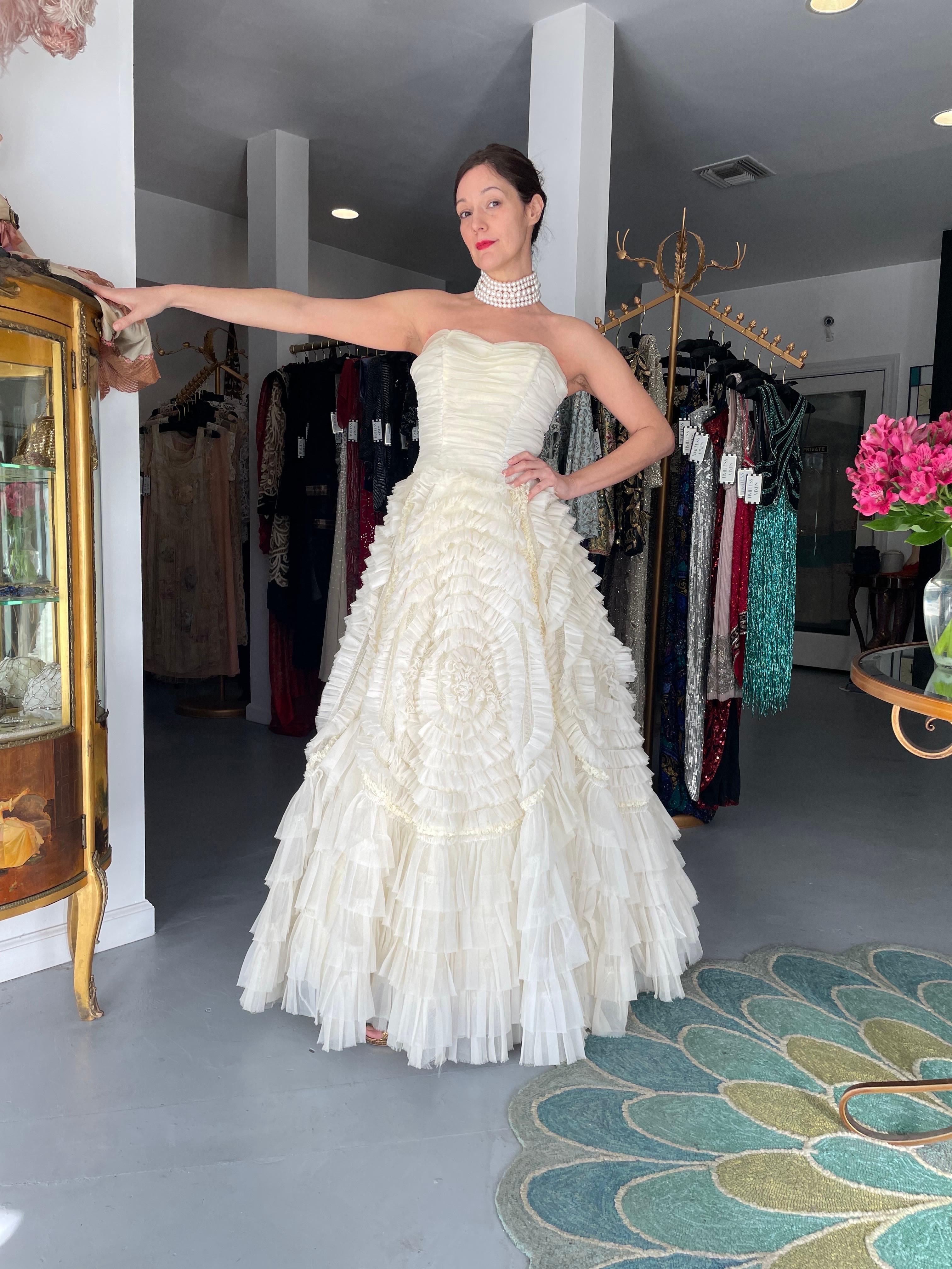 An absolutely breathtaking and ultra rare creamy ivory chiffon strapless full skirted ballgown dating back to the mid 1950's. As you can see, the design was heavily influenced by Christian Dior and any French inspired fashion pieces from this period