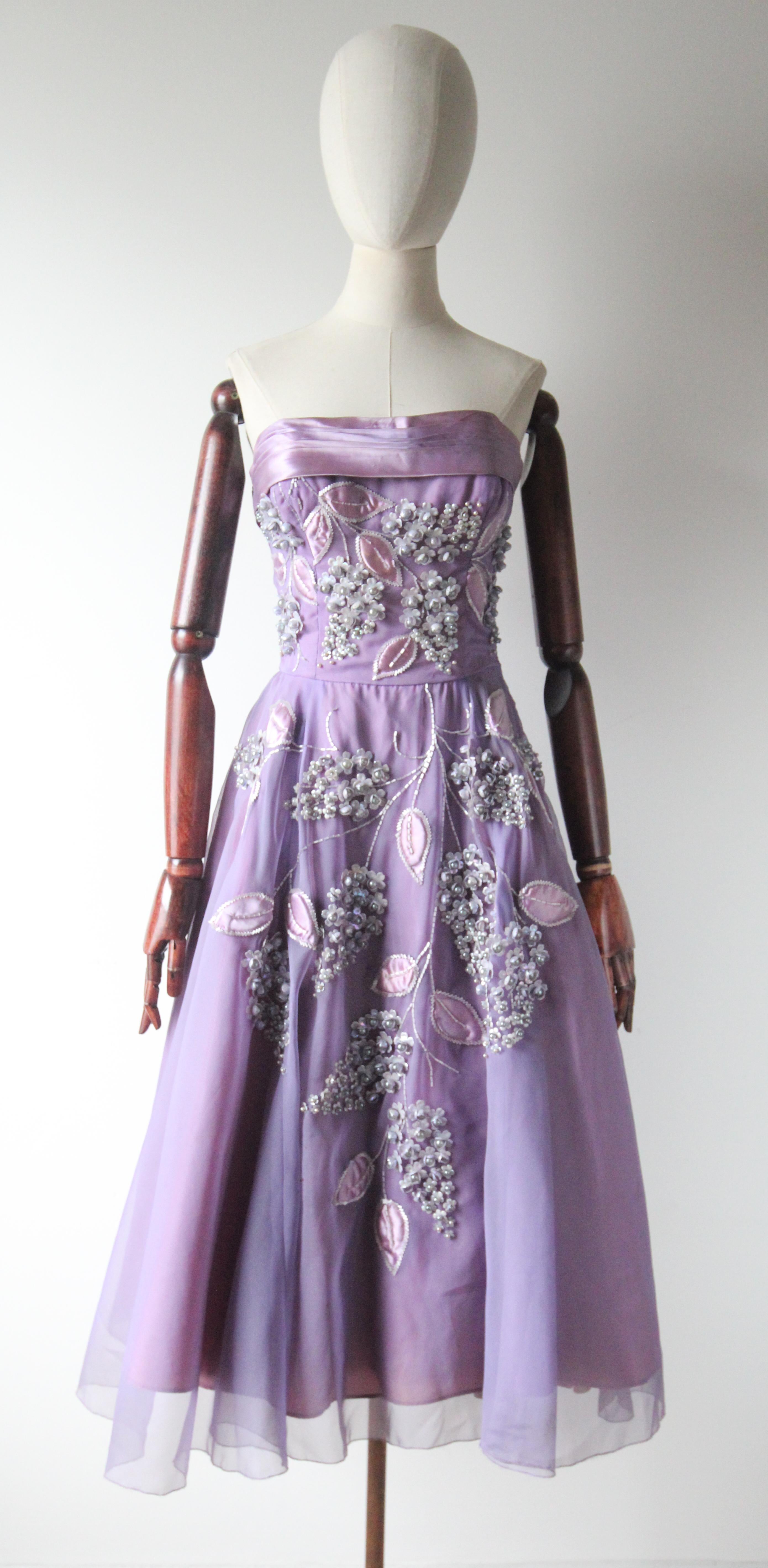 Dieses wahrhaft prächtige lilafarbene Kleid aus Chiffon und Satin aus den 1950er Jahren mit einer passenden Satin-Schaljacke, verziert mit einem Muster aus lilafarbenen Blumen mit irisierenden Blumenperlen, grauen Perlen und lilafarbenen