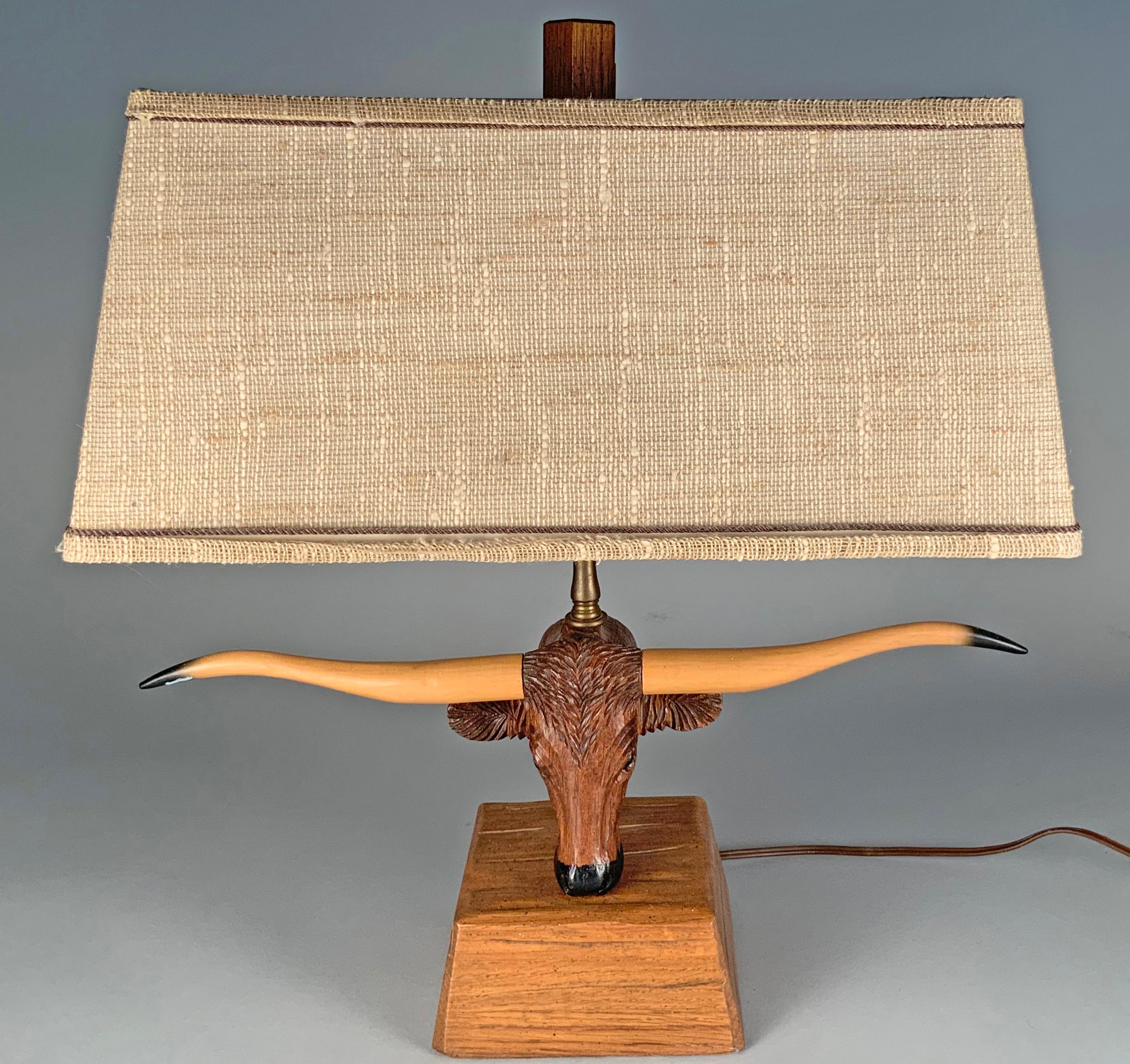 A very charming vintage 1950s small table lamp, with a base of carved oak, and the head of a Texas Longhorn steer with long elegant horns. Along with the original shade. Wonderful scale and design. Designed by Bruno Winter for the A. Brandt company.