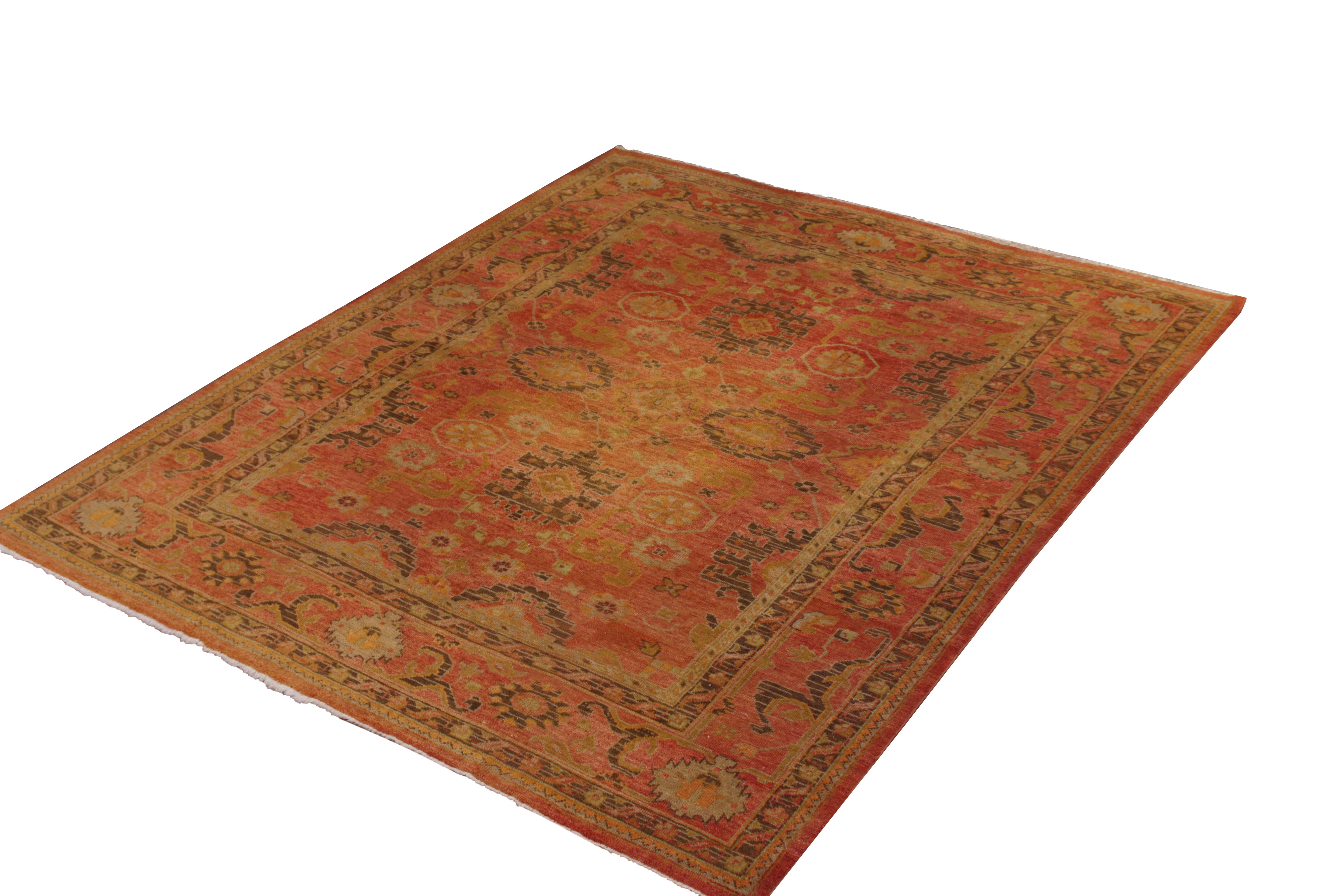 Hand knotted in wool originating from Turkey circa 1950-1960, this vintage Oushak rug enjoys a distinctively appealing, rich red colorway with a subtle pink accent, a warmer variation of this celebrated hue lending a warm complement to the rich