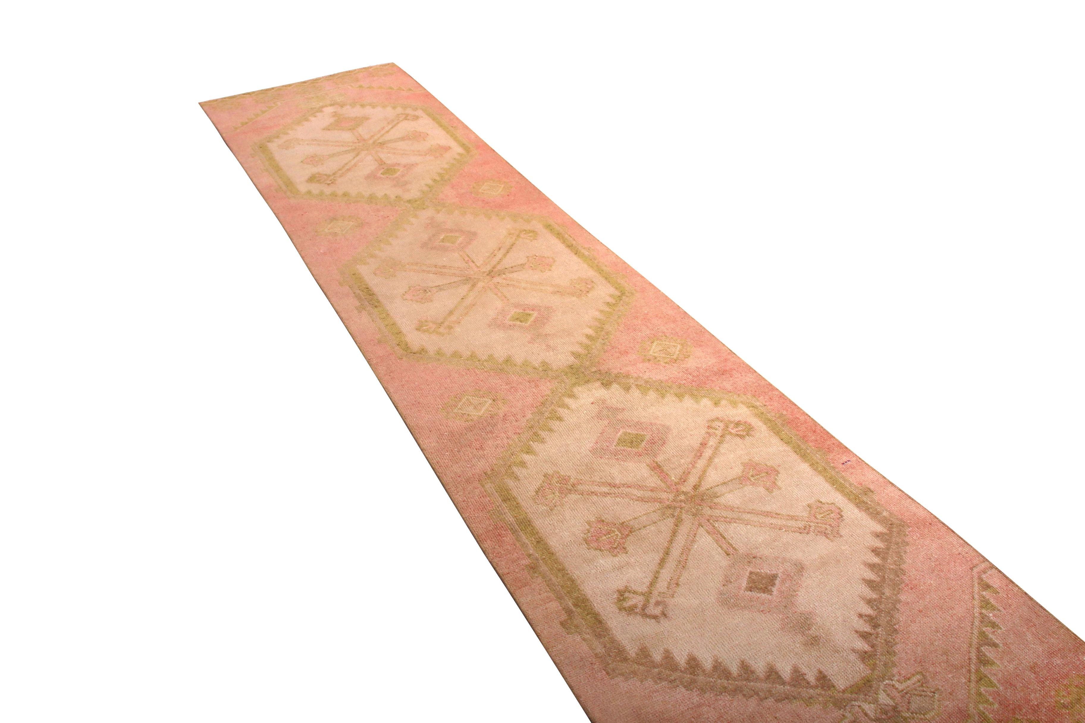 Made with handwoven wool originating from Turkey between 1950-1960, this vintage midcentury Kilim runner enjoys the distinction and gentility of a seldom-seen pink colorway, gracefully accented by a play of golden-beige and cream hues lending a